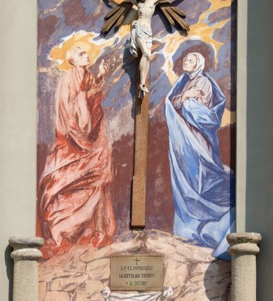 Zdjęcie nr 16: Kościół murowany, składa się z nawy i zwróconego na południe prezbiterium, do którego przylega zakrystia, nad którą znajduje się skarbiec; od północy wieża. Prezbiterium jest węższe od nawy, o zaokrąglonych narożach, oddzielone od prostokątnej nawy łukiem tęczowym. Ściany kościoła gładkie, przeprute półkolistymi oknami – dwoma w prezbiterium, sześcioma w nawie. Od zachodu chór wsparty na dwóch kolumnach, z balustradą wyłamaną na środku, dekorowaną u spodu lambrekinem. Ściany kościoła gładkie, w dolnej partii osłonięte drewnianą boazerią, z wnęką na chrzcielnicę po lewej i drugą na drzwi z prawej strony. Wnętrze przekrywają stropy – zwierciadlany w prezbiterium i płaski  z fasetami w nawie. Na nich oraz w górnej partii ścian polichromia. Nad prezbiterium wizerunek zmartwychwstałego Chrystusa, nad nawą zakomponowana w kole scena adoracji Najświętszej Marii Panny przez apostołów, poniżej, na ścianach medaliony z postaciami ważnych osobistości, świętych i aniołów. Główne drzwi od północy, boczne od zachodu. 
Kościół posadowiony na cokole. Elewacja frontowa ze zdwojonym ryzalitem, którego środek odpowiada szerokości wieży; podziały poziome przeprowadzone przy pomocy gzymsów. Na osi wejście i  okno, oba w boniowanym obramieniu. Okno ujmuje polichromowana scena Zwiastowania. Ryzalit wieńczy trójkątny fronton. Cofnięty ryzalit w dolnej partii boniowany, wyżej gładki, zwieńczony ćwierćkolistymi fragmentami przerwanego przyczółka. Boki elewacji frontowej gładkie, zwieńczone frontonem przerwanym na masyw czworobocznej wieży przeprutej z każdej strony oknem w kształcie stojącego prostokąta zamkniętego łukiem pełnym. Elewacje boczne gładkie, przeprute półkolistymi oknami. Od wschodu poniżej okien szare płyciny, od południa, w kapliczkowej oprawie grupa Ukrzyżowania. Dach nad nawą dwuspadowy, nad prezbiterium trójspadowy, dach wieńczy baniasty hełm z latarnią zakończony krzyżem, na kalenicy barokowa wieżyczka na sygnaturkę. 
