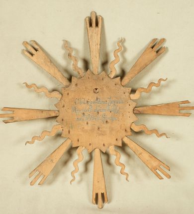 Zdjęcie nr 2: Okrągły medalion ujęty opaską z motywem korony cierniowej 
oraz profilowanym pasem; wewnątrz płaskorzeźbiony wizerunek Chrystusa. Twarz ma trójkątną, o dużych, migdałowatych, zamkniętych oczach, prostym nosie, wąskich ustach; okoloną krótką, rozdwajającą się brodą oraz lekko kręconymi włosami. Na głowie ma koronę cierniową. Medalion ujęty motywem trójkątów oraz glorią złożoną z ułożonych naprzemiennie promieni strzępionych i falistych. Twarz Chrystusa polichromowana naturalistycznie z zaznaczonymi ranami na głowie; medalion i gloria złocone i srebrzone. Na odwrocie napis „Oblicze Pana Jezusa / Rzeźbił dnia 28/X. / w 1939 r. WGórka.”



