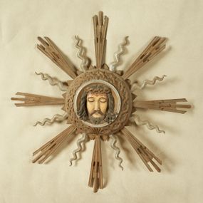 Zdjęcie nr 1: Okrągły medalion ujęty opaską z motywem korony cierniowej 
oraz profilowanym pasem; wewnątrz płaskorzeźbiony wizerunek Chrystusa. Twarz ma trójkątną, o dużych, migdałowatych, zamkniętych oczach, prostym nosie, wąskich ustach; okoloną krótką, rozdwajającą się brodą oraz lekko kręconymi włosami. Na głowie ma koronę cierniową. Medalion ujęty motywem trójkątów oraz glorią złożoną z ułożonych naprzemiennie promieni strzępionych i falistych. Twarz Chrystusa polichromowana naturalistycznie z zaznaczonymi ranami na głowie; medalion i gloria złocone i srebrzone. Na odwrocie napis „Oblicze Pana Jezusa / Rzeźbił dnia 28/X. / w 1939 r. WGórka.”



