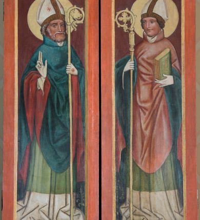 Zdjęcie nr 16: Tryptyk z wizerunkiem Matki Boskiej z Dzieciątkiem w środkowej kwaterze, ze skrzydłami z przedstawieniami na awersie św. Katarzyny i św. Barbary, a na rewersie św. Mikołaja i św. Stanisława. Środkowa kwatera w formie stojącego prostokąta z przedstawieniem Marii ukazanej w półpostaci, zwróconej w trzech czwartych w lewo, z pochyloną głową. Na lewym ramieniu podtrzymuje siedzące Dzieciątko, prawą dłonią wskazuje na nie. Twarz ma owalną, o migdałowatych oczach, prostym, wąskim nosie i małych, pełnych ustach. Ubrana jest w niebieską suknię, ze złoconymi lamówkami oraz ciemnoniebieski maforion w złocone gwiazdy, ze złoconymi lamówkami i ciemnoczerwoną podszewką, narzucony na głowę i ramiona, zapięty złoconą klamrą pod szyją. Dzieciątko ukazane w pozycji siedzącej, pochylone, zwrócone w trzech czwartych w prawo, lewą ręką opiera księgę na nodze, prawą wyciąga przed siebie w geście błogosławieństwa. Twarz ma owalną, o dużych, migdałowatych oczach, krótkim nosie i pełnych ustach, okoloną jasnymi, kręconymi i krótkimi włosami. Dzieciątko ubrane jest w luźną ciemnoniebieską tunikę o złoconym, kwiatowym wzorze, ze złoconym galonem. Postacie ukazane na złoconym i srebrzonym tle z rytą w zaprawie wicią roślinną z kwiatami. Wokół ich głów ryte w zaprawie nimby. W lewym dolnym rogu obrazu ukazane niewielkie postacie dwóch klęczących kobiet, zwróconych w trzech czwartych w lewo, z dłońmi złożonymi w geście modlitwy, z różańcami. W prawym dolnym rogu ukazany niewielki klęczący mężczyzna, zwrócony w trzech czwartych w prawo, z dłońmi złożonymi w geście modlitwy. 
Na awersie lewego skrzydła przedstawienie św. Katarzyny Aleksandryjskiej ujętej w całej postaci, zwróconej w trzech czwartych w lewo, z pochyloną głową, stojącej na postaci swojego oprawcy. W lewej, ugiętej na tle piersi ręce trzyma miecz, skierowany ostrzem w górę, prawą, opuszczoną w dół przytrzymuje przy boku koło. Twarz ma owalną, o wysokim czole, małych, migdałowatych oczach, prostym, krótkim nosie i małych ustach, okoloną długimi, brązowymi włosami, opadającymi wzdłuż ramion. Na głowie ma koronę otwartą. Ubrana jest w jasnozieloną suknię oraz jasnozielony, obfity płaszcz z czerwoną podszewką, zapięty pod szyją broszą, zarzucony na ramiona i podtrzymywany z przodu postaci. Święta stoi na niewielkiej postaci leżącego mężczyzny, ubranego w bogaty, ciemnoniebieski strój, ze złoconym pazem, z koroną otwartą na głowie. Katarzyna ukazana na złoconym i srebrzonym tle z rytą w zaprawie wicią roślinną z kwiatami. Wokół jej głowy ryty w zaprawie nimb. 
Na awersie prawego skrzydła przedstawienie św. Barbary ukazanej w całej postaci, zwróconej w trzech czwartych w prawo, z pochyloną głową, stojącej na postaci swojego oprawcy. W prawej, wyciągniętej przed siebie ręce podtrzymuje wieżę, lewą trzyma płaszcz. Twarz ma owalną, o wysokim czole, małych, migdałowatych oczach, prostym, krótkim nosie i małych ustach, okoloną długimi, jasnobrązowymi włosami, opadającymi wzdłuż ramion. Na głowie ma koronę otwartą. Ubrana jest w ciemnoniebieską suknię, przepasaną w talii oraz czerwony płaszcz z zieloną podszewką, zapięty pod szyją broszą, zarzucony na ramiona i podtrzymywany z przodu postaci. Święta stoi na niewielkiej postaci leżącego mężczyzny, ubranego w bogaty, ciemnoniebieski strój. Barbara ukazana na złoconym i srebrzonym tle z rytą w zaprawie wicią roślinną z kwiatami. Wokół jej głowy ryty w zaprawie nimb. 
Na rewersie lewego skrzydła przedstawienie św. Mikołaja ukazanego w całej postaci, zwróconego w trzech czwartych w lewo. W lewej ręce trzyma pastorał, prawą unosi w geście błogosławieństwa. Twarz ma pociągłą, o małych, migdałowatych oczach, prostym nosie i wąskich ustach, okoloną, krótką kręconą brodą i siwymi, krótkimi włosami skręconymi w pukle. Na głowie ma białą infułę z brązową opaską. Ubrany jest w białą albę, zieloną rokietę oraz obfity, niebieski ornat z czerwoną podszewką. Wokół jego głowy jasnożółty nimb. Święty ukazany jako stojący na trawie, z jednolitym, ciemnoczerwonym tłem. 
Na rewersie prawego skrzydła przedstawienie św. Stanisława ukazanego w całej postaci, zwróconego w trzech czwartych w prawo. W prawej ręce trzyma pastorał, lewą podtrzymuje przy boku księgę. Twarz ma pociągłą, o małych, migdałowatych oczach, prostym nosie i wąskich ustach, okoloną krótkimi, brązowymi włosami. Na głowie ma białą infułę z brązową opaską. Ubrany jest w białą albę, zieloną rokietę oraz obfity, czerwony ornat z niebieską podszewką. Wokół jego głowy jasnożółty nimb. Święty ukazany jako stojący na trawie, z jednolitym, ciemnoczerwonym tłem. 
Każdy z trzech obrazów ujęty osobną profilowaną ramą, złoconą z czerwoną obwódką. Skrzydła przymocowane do środkowej kwatery dwoma parami zawiasów. 
