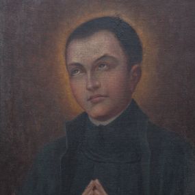 Zdjęcie nr 1: Obraz w formie stojącego prostokąta z przedstawieniem św. Stanisław Kostki ukazanego w półpostaci. Święty zwrócony jest w trzech czwartych w prawo, z dłońmi złożonymi w geście modlitwy. Twarz ma owalną, o pełnych policzkach, oczach skierowanych w górę, podniesionych brwiach, prostym nosie i pełnych ustach. Włosy ma ciemne, krótkie. Ubrany jest w czarną sutannę i płaszcz jezuicki. Święty został ukazany na brązowym tle, rozświetlonym wokół jego głowy. Obraz ujęty szeroką ramą wypełnioną pozłacanym, ażurowym suchym akantem. 