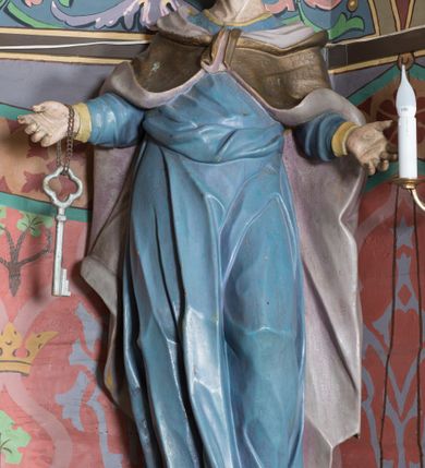 Zdjęcie nr 41: Nastawa ołtarzowa architektoniczna, jednoosiowa, jednokondygnacyjna ze zwieńczeniem, ustawiona na dwustrefowym cokole, z wyodrębnionymi dwiema parami prostopadłościanów. Ołtarz kamienny, wolnostojący, ustawiony na dwustopniowej podstawie, ujęty po bokach fryzowanymi konsolami. Mensa kamienna z marmurowym portatylem. Na przedniej ściance wyrzeźbiona w licu płycina, ujęta kanelowanymi lizenami, z monogramem IHS w polu. Na ołtarzu ustawione tabernakulum z tronem wystawienia. Tabernakulum w formie drewnianej skrzynki z obitymi blachą prostokątnymi drzwiczkami, ujętymi ramą. W ich polu medalion z przedstawieniem pelikana karmiącego młode na tle krzyża. Tron wystawienia w formie obrotowej, trójdzielnej niszy o wykroju stojącego prostokąta zamkniętego stylizowanym łukiem półokrągłym, zwieńczonej gzymsem. Nisza flankowana dekoracją w postaci liści ostrokrzewu i kampanuli, na gzymsie rocaille. Tabernakulum i tron ujęte parą niższych kolumn o kapitelach kompozytowych, na wysokich cokołach, dźwigających imposty, na których stoją wazony oraz spływami zakończonymi cokołami z fragmentami przerwanego przyczółka, na których klęczą adorujące anioły. Spływy dekorowane rocaille'em z podwieszonymi kampanulami. Kondygnacja ujęta dwiema parami pilastrów i stojących przed nimi kolumn o kapitelach kompozytowych, ustawionymi delikatnie pod kątem względem lica, wewnętrzna para wysunięta do przodu. Po wewnętrznej stronie ołtarza para pilastrów, których konsole podtrzymują belkowanie, a trzony dekorowane są zwisami roślinnymi, na ich tle figury św. Joachima i św. Anny. Podpory dźwigają pełne belkowanie, wyłamane na ich osi, przerwane nad polem środkowym oraz fragmenty przerwanego, falistego przyczółka z siedzącymi puttami, a także wolutowe cokoły z wazonami na zewnętrznych krawędziach belkowania. Fryz dekorowany rozetami. W polu środkowym nisza w formie stojącego prostokąta zamkniętego łukiem półkolistym nadwieszonym, ujęta profilowaną ramą z mniejszym obrazem Matki Boskiej z Dzieciątkiem oraz przedstawieniem św. Klemensa na zasuwie. Powyżej rokokowy kartusz z monogramem Marii, na którym dwa putta trzymają koronę, z podwieszonymi zwisami kwiatowymi, ujmującymi ramę pola głównego poniżej. Zwieńczenie w formie stojącego prostokąta z wolutowymi uszakami, zamkniętego gzymsem w formie łuku odcinkowego nadwieszonego. W polu rzeźbiarskie przedstawienie półpostaci Boga Ojca pośród obłoków, na tle glorii promienistej, ujętego przez siedzące na gzymsie, adorujące aniołki. Ołtarz flankują umocowane do ścian konsole z figurami św. Piotra i św. Pawła. Struktura w całości polichromowana w kolorze jasnoniebieskim, z niebieskimi i bladoróżowymi detalami, kolumny, profile i ornamentyka złocone, detale srebrzone.  
