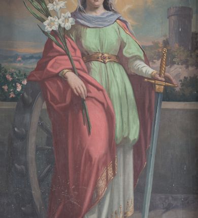 Zdjęcie nr 1: Obraz w formie stojącego prostokąta z przedstawieniem św. Katarzyny Aleksandryjskiej. Święta ukazana w całej postaci, frontalnie, w kontrapoście. W lewej ręce trzyma rękojeść miecza zwróconego ostrzem w dół, prawy łokieć opiera na stojącym obok kole, w dłoni trzyma liść palmy i gałązkę lilii. Katarzyna ma owalną twarz z okrągłymi oczami, prostym nosem i pełnymi ustami, okoloną długimi, brązowymi włosami opadającymi na ramiona. Ubrana jest w białą, długą suknię spodnią ze złoconą lamówką, jasnozieloną suknię wierzchnią sięgającą kolan, ze złotym pasem w talii, na ramiona ma narzucony czerwony płaszcz ze złotą lamówką, opadający na prawą nogę i bok postaci. Pod szyją ma białą podwikę, na głowie zaś półprzeźroczysty welon i diadem. Święta ukazana na tle niskiego muru i kamiennej posadzki, z widocznym w tle pejzażem z wieżą po lewej stronie. Zachmurzone niebo rozstępuje się wokół głowy świętej, na którą padają promienie światła. W prawym dolnym rogu sygnatura „pinx[it] / M[arian] Szczurowski / 1910”. 