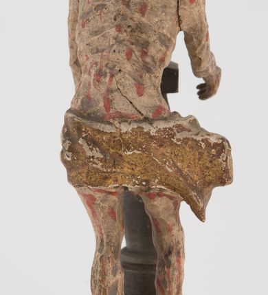 Zdjęcie nr 2: Pełnoplastyczna figurka Chrystusa z ruchomymi rękami, stojącego przy słupie ustawiona jest na owalnej podstawie. Chrystus stoi w wykroku, delikatnie pochylony ku słupowi, z głową skierowaną w prawo, z rękami wysuniętymi przed siebie, ujmującymi słup biczowania. Twarz ma szczupłą, pociągłą, o uwypuklonych kościach policzkowych, dużych oczach i nosie, okoloną krótką brodą i długimi, falowanymi włosami opadającymi na plecy. Ciało Chrystusa jest wychudzone, z silnie uwypuklonymi żebrami klatki piersiowej. Przez biodra ma przewiązane krótkie, obficie drapowane, złocone perizonium ze zwisem tkaniny na prawym boku. Słup w formie tralki na cokole. Polichromia ciała naturalistyczna, z zaznaczonymi licznymi strużkami krwi. 
