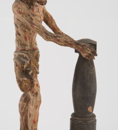 Zdjęcie nr 1: Pełnoplastyczna figurka Chrystusa z ruchomymi rękami, stojącego przy słupie ustawiona jest na owalnej podstawie. Chrystus stoi w wykroku, delikatnie pochylony ku słupowi, z głową skierowaną w prawo, z rękami wysuniętymi przed siebie, ujmującymi słup biczowania. Twarz ma szczupłą, pociągłą, o uwypuklonych kościach policzkowych, dużych oczach i nosie, okoloną krótką brodą i długimi, falowanymi włosami opadającymi na plecy. Ciało Chrystusa jest wychudzone, z silnie uwypuklonymi żebrami klatki piersiowej. Przez biodra ma przewiązane krótkie, obficie drapowane, złocone perizonium ze zwisem tkaniny na prawym boku. Słup w formie tralki na cokole. Polichromia ciała naturalistyczna, z zaznaczonymi licznymi strużkami krwi. 
