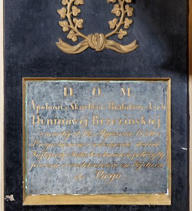Zdjęcie nr 1: Epitafium w kształcie stojącego prostokąta. W polu kwadratowa płycina z rytą, złoconą inskrypcją „D(EO) O(PTIMO) M(AXIMO) / Apolonii z Skarbków Białobrzeskich / Duninowéj Brzezińskiéj / zmarłéj d(nia) 12. stycznia 1830r(oku) / Przywiązane i wdzięczne dzieci / Najlepszéj Matce ten kamień położyły / prosząc o westchnienie za Jéj duszę / do Boga.” Nad płyciną rzeźbiony, złocony wieniec z trójlistnych gałązek, przewiązany u dołu wstęgą. 

