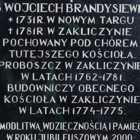 Zdjęcie nr 1: Tablica w kształcie stojącego prostokąta z kutą inskrypcją „Ś(więtej) P(amięci) / KS(IĄDZ) WOJCIECH BRANDYSIEWICZ / * 1731 R(OKU) W NOWYM TARGU /† 1781 R(OKU) W ZAKLICZYNIE / POCHOWANY POD CHÓREM / TUTEJSZEGO KOŚCIOŁA. / PROBOSZCZ W ZAKLICZYNIE / W LATACH 1762-1781. / BUDOWNICZY OBECNEGO / KOŚCIOŁA W ZAKLICZYNIE / W LATACH 1774-1775. / Z MODLITWĄ, WDZIĘCZNOŚCIĄ I PAMIĘCIĄ / W ROKU JUBILEUSZOWYM 2000: / KS(IĄDZ) STANISŁAW PAJĄK-PROBOSZCZ I WIERNI PARAFII ZAKLICZYN. / R(EQUIESCAT) I(N) P(ACE)”. U góry, pomiędzy literami „Ś” i „P” łaciński krzyżyk.