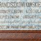Zdjęcie nr 1: Epitafium w kształcie leżącego prostokąta z profilowanym obramieniem z uszakami. Na osi, w górnej części złocona, uskrzydlona główka aniołka, a w narożach złocone rozety. Pośrodku tablicy inskrypcja „PRZEZACNEMU KS(IĘDZU) PROBOSZCZOWI I KANONIKOWI / FRANCISZKOWI KAMSKIEMU / ODNOWICIELOWI KOŚCIOŁA / i OPIEKUNOWI UBOGICH. ZMARŁEMU / W 1925 ROKU. A W 50 TEM KAPŁAŃSTWA w KRAKOWIE / WDZIĘCZNI PARAFIJANIE ZAKLICZYNA.” Pole epitafium marmoryzowane w kolorze niebieskim, a rama marmoryzowana w kolorze ciemnobrązowym.