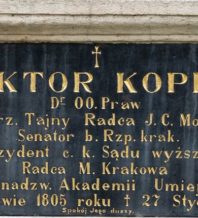 Zdjęcie nr 1: Tablica epitafijna w kształcie leżącego prostokąta w kamiennym, profilowanym obramieniu. W polu złocona inskrypcja „WIKTOR KOPFF / D(okto)r O(bojga) Praw / c(esarski) k(rólewski) rz(eczywisty) Tajny Radca J(ego) C(esarskiej) Mości / Senator b(yły) Rz(eczy)p(ospolitej) krak(owskiej) / Prezydent c(esarskiego) k(rólewskiego) Sądu wyższego / Radca M(iasta) Krakowa / Członek nadzw(yczajny) Akademii Umiejętności / * w Krakowie 1805 roku † 27 Stycznia 1889. / Spokój Jego duszy.” Nad inskrypcją złocony, łaciński krzyżyk. 