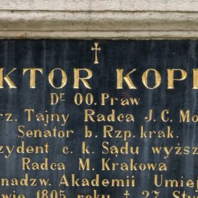 Zdjęcie nr 1: Tablica epitafijna w kształcie leżącego prostokąta w kamiennym, profilowanym obramieniu. W polu złocona inskrypcja „WIKTOR KOPFF / D(okto)r O(bojga) Praw / c(esarski) k(rólewski) rz(eczywisty) Tajny Radca J(ego) C(esarskiej) Mości / Senator b(yły) Rz(eczy)p(ospolitej) krak(owskiej) / Prezydent c(esarskiego) k(rólewskiego) Sądu wyższego / Radca M(iasta) Krakowa / Członek nadzw(yczajny) Akademii Umiejętności / * w Krakowie 1805 roku † 27 Stycznia 1889. / Spokój Jego duszy.” Nad inskrypcją złocony, łaciński krzyżyk. 