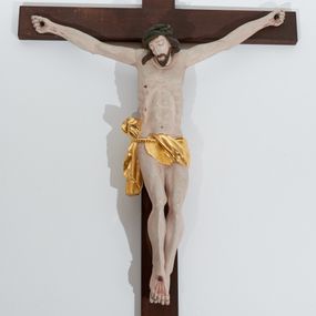 Zdjęcie nr 1: Chrystus przybity do krzyża trzema gwoździami. Sylwetka w delikatnym zwisie, o silnie zaznaczonej anatomii ciała, z guzowato podkreśloną linią żeber i delikatnie zaznaczonymi śladami męki; prawa stopa założona na lewą. Głowa delikatnie opadająca na prawe ramię, twarz podłużna i okolona krótkim zarostem, oczy zamknięte, nos podłużny i wąski, usta zamknięte; włosy długie, spływające na prawe ramię, a z lewej strony bujnie zawinięte do tyłu, na głowie szeroka, zielona korona cierniowa. Perizonium w formie tkaniny przewiązanej na sznurze na prawym boku, odsłaniające prawe udo. Krzyż drewniany, prosty. Nad głową Chrystusa zawieszony titulus w kształcie pionowej tabliczki z napisem „INRI”. Partie ciała polichromowane naturalistycznie, perizonium złocone.



