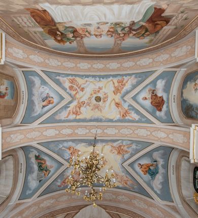 Zdjęcie nr 23: Kościół orientowany, jest budowlą murowaną z cegły i kamienia, na rzucie podłużnym. Korpus jednonawowy i trójprzęsłowy. Stosunkowo szerokie, trójprzęsłowe, zamknięte trójbocznie prezbiterium z przylegającą od północy zakrystią. Na osi kościoła przylega do fasady trójkondygnacyjna wieża z kruchtą w przyziemiu i przyległością od południa, w której mieszczą się prowadzące na wieżę schody.  Od południa i zachodu, na wysokości trzeciego przęsła do korpusu przylega kaplic na rzutach zbliżonych do kwadratów, z czego południową od wschodu i zachodu flankuje para krucht. Nawa, prezbiterium i kaplica północna przekryte są sklepieniami kolebkowymi z lunetami wspartymi na parach lub pojedynczych pilastrach. Kaplica południowa nakryta jest kopułą wspartą na 4 pendentywach. Artykulację ścian na zewnątrz korpusu nawowego i prezbiterium stanowi zespół przypór. Naroża kaplicy południowej ujmują zwielokrotnione pilastry wpierające obiegający bryłę gzyms wieńczący. Naroża kaplicy północnej ujmuje para neogotyckich przypór, natomiast północną ścianę wieńczy neogotycki szczyt schodkowy. 
Do wnętrza prowadzi 6 otworów drzwiowych – 1 w kruchcie w wieży ujęte kamienny, półkoliście zamkniętym portalem schodkowym z dwuskrzydłowymi drzwiami z nadświetlem, 1 zamknięte łukiem półkolistym w przyległości obok wieży, 3 w kruchtach flankujących kaplicę południową – z czego w zachodniej jedno w formie dużych dwuskrzydłowych drzwi z kwaterami bocznymi i nadświetlem, we wschodniej 2 ujęte prostokątnymi, kamiennymi portalami z wąskim nadświetlem i parą uszaków, zwieńczonych parą stykających się wolut z krzyżem na kuli w szczycie oraz 1 prowadzące do zakrystii. Okna korpusu nawowego i prezbiterium w kształcie stojących prostokątów zamkniętych półkoliście, z czego w prezbiterium są smukłe i wysokie. Okna kaplicy północnej zamknięte łukiem koszowym, natomiast kaplicy południowej w postaci prostokątów ujętych kamiennymi obramieniami z uszakami na narożach. 3 z 4 ścian wieży przeprute oknami, po 1 na każdej z kondygnacji, z czego na pierwszej zamknięte półkoliście, na drugiej w kształcie stojącego prostokąta i na trzeciej ostrołukowe. Wieżę wieńczy ceglany szczyt z wydzielonym gzymsami fryzem arkadkowym, wyżej 4 trójkątne szczyty umieszczone na osiach każdej ze ścian ujęte w narożach 4 małymi pinaklami i hełmem pośrodku w formie wysokiego pinakla. Korpus nawowy i prezbiterium przekrywa dach dwuspadowy, kryty blachą, z pinaklową wieżyczką na sygnaturkę na połączeniu tych przestrzeni, kaplicę południową kopuła z latarnią, przylegające do niej kruchty dachy pulpitowe, natomiast kaplica północna ma dach dwuspadowy. Otynkowane ściany kościoła są pomalowane w kolorze białym, miejscami pozostawiony kamienny mur.     
