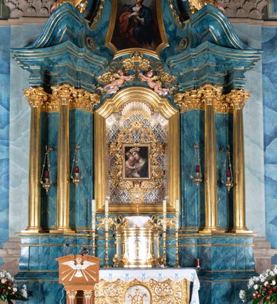 Zdjęcie nr 22: Kościół orientowany, jest budowlą murowaną z cegły i kamienia, na rzucie podłużnym. Korpus jednonawowy i trójprzęsłowy. Stosunkowo szerokie, trójprzęsłowe, zamknięte trójbocznie prezbiterium z przylegającą od północy zakrystią. Na osi kościoła przylega do fasady trójkondygnacyjna wieża z kruchtą w przyziemiu i przyległością od południa, w której mieszczą się prowadzące na wieżę schody.  Od południa i zachodu, na wysokości trzeciego przęsła do korpusu przylega kaplic na rzutach zbliżonych do kwadratów, z czego południową od wschodu i zachodu flankuje para krucht. Nawa, prezbiterium i kaplica północna przekryte są sklepieniami kolebkowymi z lunetami wspartymi na parach lub pojedynczych pilastrach. Kaplica południowa nakryta jest kopułą wspartą na 4 pendentywach. Artykulację ścian na zewnątrz korpusu nawowego i prezbiterium stanowi zespół przypór. Naroża kaplicy południowej ujmują zwielokrotnione pilastry wpierające obiegający bryłę gzyms wieńczący. Naroża kaplicy północnej ujmuje para neogotyckich przypór, natomiast północną ścianę wieńczy neogotycki szczyt schodkowy. 
Do wnętrza prowadzi 6 otworów drzwiowych – 1 w kruchcie w wieży ujęte kamienny, półkoliście zamkniętym portalem schodkowym z dwuskrzydłowymi drzwiami z nadświetlem, 1 zamknięte łukiem półkolistym w przyległości obok wieży, 3 w kruchtach flankujących kaplicę południową – z czego w zachodniej jedno w formie dużych dwuskrzydłowych drzwi z kwaterami bocznymi i nadświetlem, we wschodniej 2 ujęte prostokątnymi, kamiennymi portalami z wąskim nadświetlem i parą uszaków, zwieńczonych parą stykających się wolut z krzyżem na kuli w szczycie oraz 1 prowadzące do zakrystii. Okna korpusu nawowego i prezbiterium w kształcie stojących prostokątów zamkniętych półkoliście, z czego w prezbiterium są smukłe i wysokie. Okna kaplicy północnej zamknięte łukiem koszowym, natomiast kaplicy południowej w postaci prostokątów ujętych kamiennymi obramieniami z uszakami na narożach. 3 z 4 ścian wieży przeprute oknami, po 1 na każdej z kondygnacji, z czego na pierwszej zamknięte półkoliście, na drugiej w kształcie stojącego prostokąta i na trzeciej ostrołukowe. Wieżę wieńczy ceglany szczyt z wydzielonym gzymsami fryzem arkadkowym, wyżej 4 trójkątne szczyty umieszczone na osiach każdej ze ścian ujęte w narożach 4 małymi pinaklami i hełmem pośrodku w formie wysokiego pinakla. Korpus nawowy i prezbiterium przekrywa dach dwuspadowy, kryty blachą, z pinaklową wieżyczką na sygnaturkę na połączeniu tych przestrzeni, kaplicę południową kopuła z latarnią, przylegające do niej kruchty dachy pulpitowe, natomiast kaplica północna ma dach dwuspadowy. Otynkowane ściany kościoła są pomalowane w kolorze białym, miejscami pozostawiony kamienny mur.     
