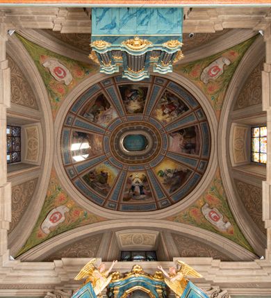 Zdjęcie nr 27: Kościół orientowany, jest budowlą murowaną z cegły i kamienia, na rzucie podłużnym. Korpus jednonawowy i trójprzęsłowy. Stosunkowo szerokie, trójprzęsłowe, zamknięte trójbocznie prezbiterium z przylegającą od północy zakrystią. Na osi kościoła przylega do fasady trójkondygnacyjna wieża z kruchtą w przyziemiu i przyległością od południa, w której mieszczą się prowadzące na wieżę schody.  Od południa i zachodu, na wysokości trzeciego przęsła do korpusu przylega kaplic na rzutach zbliżonych do kwadratów, z czego południową od wschodu i zachodu flankuje para krucht. Nawa, prezbiterium i kaplica północna przekryte są sklepieniami kolebkowymi z lunetami wspartymi na parach lub pojedynczych pilastrach. Kaplica południowa nakryta jest kopułą wspartą na 4 pendentywach. Artykulację ścian na zewnątrz korpusu nawowego i prezbiterium stanowi zespół przypór. Naroża kaplicy południowej ujmują zwielokrotnione pilastry wpierające obiegający bryłę gzyms wieńczący. Naroża kaplicy północnej ujmuje para neogotyckich przypór, natomiast północną ścianę wieńczy neogotycki szczyt schodkowy. 
Do wnętrza prowadzi 6 otworów drzwiowych – 1 w kruchcie w wieży ujęte kamienny, półkoliście zamkniętym portalem schodkowym z dwuskrzydłowymi drzwiami z nadświetlem, 1 zamknięte łukiem półkolistym w przyległości obok wieży, 3 w kruchtach flankujących kaplicę południową – z czego w zachodniej jedno w formie dużych dwuskrzydłowych drzwi z kwaterami bocznymi i nadświetlem, we wschodniej 2 ujęte prostokątnymi, kamiennymi portalami z wąskim nadświetlem i parą uszaków, zwieńczonych parą stykających się wolut z krzyżem na kuli w szczycie oraz 1 prowadzące do zakrystii. Okna korpusu nawowego i prezbiterium w kształcie stojących prostokątów zamkniętych półkoliście, z czego w prezbiterium są smukłe i wysokie. Okna kaplicy północnej zamknięte łukiem koszowym, natomiast kaplicy południowej w postaci prostokątów ujętych kamiennymi obramieniami z uszakami na narożach. 3 z 4 ścian wieży przeprute oknami, po 1 na każdej z kondygnacji, z czego na pierwszej zamknięte półkoliście, na drugiej w kształcie stojącego prostokąta i na trzeciej ostrołukowe. Wieżę wieńczy ceglany szczyt z wydzielonym gzymsami fryzem arkadkowym, wyżej 4 trójkątne szczyty umieszczone na osiach każdej ze ścian ujęte w narożach 4 małymi pinaklami i hełmem pośrodku w formie wysokiego pinakla. Korpus nawowy i prezbiterium przekrywa dach dwuspadowy, kryty blachą, z pinaklową wieżyczką na sygnaturkę na połączeniu tych przestrzeni, kaplicę południową kopuła z latarnią, przylegające do niej kruchty dachy pulpitowe, natomiast kaplica północna ma dach dwuspadowy. Otynkowane ściany kościoła są pomalowane w kolorze białym, miejscami pozostawiony kamienny mur.     
