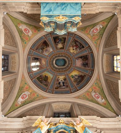 Zdjęcie nr 26: Kościół orientowany, jest budowlą murowaną z cegły i kamienia, na rzucie podłużnym. Korpus jednonawowy i trójprzęsłowy. Stosunkowo szerokie, trójprzęsłowe, zamknięte trójbocznie prezbiterium z przylegającą od północy zakrystią. Na osi kościoła przylega do fasady trójkondygnacyjna wieża z kruchtą w przyziemiu i przyległością od południa, w której mieszczą się prowadzące na wieżę schody.  Od południa i zachodu, na wysokości trzeciego przęsła do korpusu przylega kaplic na rzutach zbliżonych do kwadratów, z czego południową od wschodu i zachodu flankuje para krucht. Nawa, prezbiterium i kaplica północna przekryte są sklepieniami kolebkowymi z lunetami wspartymi na parach lub pojedynczych pilastrach. Kaplica południowa nakryta jest kopułą wspartą na 4 pendentywach. Artykulację ścian na zewnątrz korpusu nawowego i prezbiterium stanowi zespół przypór. Naroża kaplicy południowej ujmują zwielokrotnione pilastry wpierające obiegający bryłę gzyms wieńczący. Naroża kaplicy północnej ujmuje para neogotyckich przypór, natomiast północną ścianę wieńczy neogotycki szczyt schodkowy. 
Do wnętrza prowadzi 6 otworów drzwiowych – 1 w kruchcie w wieży ujęte kamienny, półkoliście zamkniętym portalem schodkowym z dwuskrzydłowymi drzwiami z nadświetlem, 1 zamknięte łukiem półkolistym w przyległości obok wieży, 3 w kruchtach flankujących kaplicę południową – z czego w zachodniej jedno w formie dużych dwuskrzydłowych drzwi z kwaterami bocznymi i nadświetlem, we wschodniej 2 ujęte prostokątnymi, kamiennymi portalami z wąskim nadświetlem i parą uszaków, zwieńczonych parą stykających się wolut z krzyżem na kuli w szczycie oraz 1 prowadzące do zakrystii. Okna korpusu nawowego i prezbiterium w kształcie stojących prostokątów zamkniętych półkoliście, z czego w prezbiterium są smukłe i wysokie. Okna kaplicy północnej zamknięte łukiem koszowym, natomiast kaplicy południowej w postaci prostokątów ujętych kamiennymi obramieniami z uszakami na narożach. 3 z 4 ścian wieży przeprute oknami, po 1 na każdej z kondygnacji, z czego na pierwszej zamknięte półkoliście, na drugiej w kształcie stojącego prostokąta i na trzeciej ostrołukowe. Wieżę wieńczy ceglany szczyt z wydzielonym gzymsami fryzem arkadkowym, wyżej 4 trójkątne szczyty umieszczone na osiach każdej ze ścian ujęte w narożach 4 małymi pinaklami i hełmem pośrodku w formie wysokiego pinakla. Korpus nawowy i prezbiterium przekrywa dach dwuspadowy, kryty blachą, z pinaklową wieżyczką na sygnaturkę na połączeniu tych przestrzeni, kaplicę południową kopuła z latarnią, przylegające do niej kruchty dachy pulpitowe, natomiast kaplica północna ma dach dwuspadowy. Otynkowane ściany kościoła są pomalowane w kolorze białym, miejscami pozostawiony kamienny mur.     
