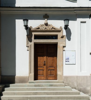 Zdjęcie nr 13: Kościół orientowany, jest budowlą murowaną z cegły i kamienia, na rzucie podłużnym. Korpus jednonawowy i trójprzęsłowy. Stosunkowo szerokie, trójprzęsłowe, zamknięte trójbocznie prezbiterium z przylegającą od północy zakrystią. Na osi kościoła przylega do fasady trójkondygnacyjna wieża z kruchtą w przyziemiu i przyległością od południa, w której mieszczą się prowadzące na wieżę schody.  Od południa i zachodu, na wysokości trzeciego przęsła do korpusu przylega kaplic na rzutach zbliżonych do kwadratów, z czego południową od wschodu i zachodu flankuje para krucht. Nawa, prezbiterium i kaplica północna przekryte są sklepieniami kolebkowymi z lunetami wspartymi na parach lub pojedynczych pilastrach. Kaplica południowa nakryta jest kopułą wspartą na 4 pendentywach. Artykulację ścian na zewnątrz korpusu nawowego i prezbiterium stanowi zespół przypór. Naroża kaplicy południowej ujmują zwielokrotnione pilastry wpierające obiegający bryłę gzyms wieńczący. Naroża kaplicy północnej ujmuje para neogotyckich przypór, natomiast północną ścianę wieńczy neogotycki szczyt schodkowy. 
Do wnętrza prowadzi 6 otworów drzwiowych – 1 w kruchcie w wieży ujęte kamienny, półkoliście zamkniętym portalem schodkowym z dwuskrzydłowymi drzwiami z nadświetlem, 1 zamknięte łukiem półkolistym w przyległości obok wieży, 3 w kruchtach flankujących kaplicę południową – z czego w zachodniej jedno w formie dużych dwuskrzydłowych drzwi z kwaterami bocznymi i nadświetlem, we wschodniej 2 ujęte prostokątnymi, kamiennymi portalami z wąskim nadświetlem i parą uszaków, zwieńczonych parą stykających się wolut z krzyżem na kuli w szczycie oraz 1 prowadzące do zakrystii. Okna korpusu nawowego i prezbiterium w kształcie stojących prostokątów zamkniętych półkoliście, z czego w prezbiterium są smukłe i wysokie. Okna kaplicy północnej zamknięte łukiem koszowym, natomiast kaplicy południowej w postaci prostokątów ujętych kamiennymi obramieniami z uszakami na narożach. 3 z 4 ścian wieży przeprute oknami, po 1 na każdej z kondygnacji, z czego na pierwszej zamknięte półkoliście, na drugiej w kształcie stojącego prostokąta i na trzeciej ostrołukowe. Wieżę wieńczy ceglany szczyt z wydzielonym gzymsami fryzem arkadkowym, wyżej 4 trójkątne szczyty umieszczone na osiach każdej ze ścian ujęte w narożach 4 małymi pinaklami i hełmem pośrodku w formie wysokiego pinakla. Korpus nawowy i prezbiterium przekrywa dach dwuspadowy, kryty blachą, z pinaklową wieżyczką na sygnaturkę na połączeniu tych przestrzeni, kaplicę południową kopuła z latarnią, przylegające do niej kruchty dachy pulpitowe, natomiast kaplica północna ma dach dwuspadowy. Otynkowane ściany kościoła są pomalowane w kolorze białym, miejscami pozostawiony kamienny mur.     
