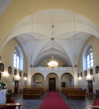 Zdjęcie nr 5: Kościół jest położony w centrum wsi, na południe od głównej drogi, na placu otoczonym płotem na kamiennej podmurówce. Wejście na plac kościelny prowadzi przez główną bramę od zachodu oraz drugą od północnego-wschodu. Kościół jest budowlą założoną na planie krzyża łacińskiego, murowaną, orientowaną z delikatnym odchyleniem ku południowi, jednonawową z transeptem, z prezbiterium zamkniętym trójbocznie, przy którym od północy jest zakrystia z emporą, a od południa kaplica. Wnętrze nawy głównej artykułowe jest dwiema płytkimi wnękami, zakończonymi półkoliście, w których w górnej części umieszczone są trójdzielne okna z maswerkami i witrażami. W prezbiterium i kaplicy sklepienie krzyżowo-żebrowe, w nawie gwieździste bez żeber. Nawę od prezbiterium oraz ramion transeptu oddzielają półkoliście zamknięte arkady. Na ścianie arkady tęczowej napis: „CHWAŁA CI TRÓJCO ŚWIĘTA”. W ramionach transeptu pojedyncze okna prostokątne, zamknięte półkoliście. Kolejne dwa okna, lecz węższe znajdują się w prezbiterium. 

Fasada dwukondygnacyjna z dostawioną wieżą na planie kwadratu. W dolnej kondygnacji fasada artykułowana parą pilastrów w narożach, podtrzymujących profilowany gzyms. Pośrodku główne wejście do kościoła zaakcentowane schodami i monumentalnym portalem z wimpergą i masywnymi kamiennymi węgarami. W górnej kondygnacji fasady uwidoczniona sylwetka wieży z każdej strony flankowana w narożach parą lizen podtrzymujących niepełne belkowanie i trójkątne przyczółki. Od frontu, po bokach wieży spływy wolutowe, w polu półkoliście zamknięte okno, a nad nim okrągłe. Na ścianach bocznych wieży analogiczne oculusy. Na szczycie wieży wysoka iglica. Pozostałe ściany kościoła artykułowe pilastrami, podtrzymującymi niepełne belkowanie zamknięte gzymsem podokapowym. Dach dwuspadowy, nakryty dachówką.

