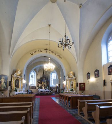 Zdjęcie nr 15: Kościół jest położony w centrum wsi, na południe od głównej drogi, na placu otoczonym płotem na kamiennej podmurówce. Wejście na plac kościelny prowadzi przez główną bramę od zachodu oraz drugą od północnego-wschodu. Kościół jest budowlą założoną na planie krzyża łacińskiego, murowaną, orientowaną z delikatnym odchyleniem ku południowi, jednonawową z transeptem, z prezbiterium zamkniętym trójbocznie, przy którym od północy jest zakrystia z emporą, a od południa kaplica. Wnętrze nawy głównej artykułowe jest dwiema płytkimi wnękami, zakończonymi półkoliście, w których w górnej części umieszczone są trójdzielne okna z maswerkami i witrażami. W prezbiterium i kaplicy sklepienie krzyżowo-żebrowe, w nawie gwieździste bez żeber. Nawę od prezbiterium oraz ramion transeptu oddzielają półkoliście zamknięte arkady. Na ścianie arkady tęczowej napis: „CHWAŁA CI TRÓJCO ŚWIĘTA”. W ramionach transeptu pojedyncze okna prostokątne, zamknięte półkoliście. Kolejne dwa okna, lecz węższe znajdują się w prezbiterium. 

Fasada dwukondygnacyjna z dostawioną wieżą na planie kwadratu. W dolnej kondygnacji fasada artykułowana parą pilastrów w narożach, podtrzymujących profilowany gzyms. Pośrodku główne wejście do kościoła zaakcentowane schodami i monumentalnym portalem z wimpergą i masywnymi kamiennymi węgarami. W górnej kondygnacji fasady uwidoczniona sylwetka wieży z każdej strony flankowana w narożach parą lizen podtrzymujących niepełne belkowanie i trójkątne przyczółki. Od frontu, po bokach wieży spływy wolutowe, w polu półkoliście zamknięte okno, a nad nim okrągłe. Na ścianach bocznych wieży analogiczne oculusy. Na szczycie wieży wysoka iglica. Pozostałe ściany kościoła artykułowe pilastrami, podtrzymującymi niepełne belkowanie zamknięte gzymsem podokapowym. Dach dwuspadowy, nakryty dachówką.

