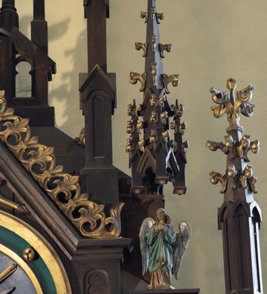 Zdjęcie nr 5: Ołtarz drewniany, prostopadłościenny, na dwustopniowej podstawie; mensa drewniana. Antepedium ujęte w narożach parą kolumienek, pole podzielone na trzy płyciny z maswerkami: zewnętrzne prostokątne, środkowa kwadratowa z monogramem Marii. Tabernakulum w kształcie drewnianej prostopadłościennej skrzynki, w formie kapliczki. Flankowane od frontu dwiema lizenami zakończonymi sterczynami z żabkami; nad polem środkowym zamknięte wimpergą. Drzwiczki w formie stojącego prostokąta zamkniętego łukiem ostrym, dekorowane w polu dwiema blendami i rozetą. Nastawa ołtarzowa architektoniczna, jednoosiowa, jednokondygnacyjna ze zwieńczeniem, z wysoką predellą. Kondygnacja ujęta dwiema parami kolumienek na wysokich, wąskich cokołach, dźwigających podwójne sterczyny, pomiędzy nimi cokoły na figury aniołów, zwieńczone baldachimami utworzonymi z konstrukcji dwóch łuków ostrych i sterczyny. W polu środkowym nisza w formie stojącego prostokąta zamkniętego łukiem ostrym, ujęta kolumienkami o skręconych trzonach (w dolnej części trzony gładkie), z obrazem św. Teresy z Lisieux; w przyłuczach dekorowana maswerkiem; zamknięta baldachimem utworzonym naprzemiennie z łuków ostrych i sterczyn. Kondygnacja ujęta po zewnętrznej stronie przyporami podtrzymywanymi przez wsporniki. Zwieńczenie w formie wimpergi dekorowanej żabkami, zakończonej krzyżem; dekorowanej maswerkiem w polu. Struktura w kolorze naturalnego drewna; detale w kolorze niebieskim, kolumny, dekoracja i profile złocone.
