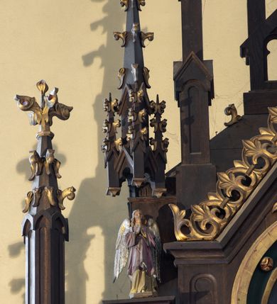 Zdjęcie nr 7: Ołtarz drewniany, prostopadłościenny, na dwustopniowej podstawie; mensa drewniana. Antepedium ujęte w narożach parą kolumienek, pole podzielone na trzy płyciny z maswerkami: zewnętrzne prostokątne, środkowa kwadratowa z monogramem Marii. Tabernakulum w kształcie drewnianej prostopadłościennej skrzynki, w formie kapliczki. Flankowane od frontu dwiema lizenami zakończonymi sterczynami z żabkami; nad polem środkowym zamknięte wimpergą. Drzwiczki w formie stojącego prostokąta zamkniętego łukiem ostrym, dekorowane w polu dwiema blendami i rozetą. Nastawa ołtarzowa architektoniczna, jednoosiowa, jednokondygnacyjna ze zwieńczeniem, z wysoką predellą. Kondygnacja ujęta dwiema parami kolumienek na wysokich, wąskich cokołach, dźwigających podwójne sterczyny, pomiędzy nimi cokoły na figury aniołów, zwieńczone baldachimami utworzonymi z konstrukcji dwóch łuków ostrych i sterczyny. W polu środkowym nisza w formie stojącego prostokąta zamkniętego łukiem ostrym, ujęta kolumienkami o skręconych trzonach (w dolnej części trzony gładkie), z obrazem św. Teresy z Lisieux; w przyłuczach dekorowana maswerkiem; zamknięta baldachimem utworzonym naprzemiennie z łuków ostrych i sterczyn. Kondygnacja ujęta po zewnętrznej stronie przyporami podtrzymywanymi przez wsporniki. Zwieńczenie w formie wimpergi dekorowanej żabkami, zakończonej krzyżem; dekorowanej maswerkiem w polu. Struktura w kolorze naturalnego drewna; detale w kolorze niebieskim, kolumny, dekoracja i profile złocone.
