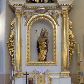 Zdjęcie nr 1: Ołtarz drewniany, prostopadłościenny, na jednostopniowej podstawie. Mensa drewniana z portatylem z marmuru dębnickiego z kwadratowym reservaculum na relikwie św. Konstancji i św. Teodora. Antepedium w formie leżącego  prostokąta ujętego grubą ramą, dekorowaną płaskorzeźbionym akantem. W polu, w centrum malowany na desce rollwerk z monogramem Marii w polu, ujęty wolutami utworzonymi z ornamentu roślinnego o wici zakończonej kampanulą. Tabernakulum w formie prostopadłościennej skrzynki o delikatnie wypukłej ściance frontowej. Całość zamknięta opasującym je z trzech stron gzymsem przyjmującym nad polem środkowym kształt łuku segmentowego podtrzymywanego przez dwie konsole utworzone z akantu. Drzwiczki w kształcie stojącego prostokąta zamkniętego łukiem półkolistym nadwieszonym, ujęte ramą. W polu ryte przedstawienie kielicha z hostią. Tabernakulum flankowane spływami wolutowymi utworzonymi z akantu. Nastawa ołtarzowa architektoniczna, jednoosiowa, jednokondygnacyjna ze zwieńczeniem, na niewielkim cokole. Kondygnacja ujęta parą kolumn o kapitelach kompozytowych dźwigających pełne belkowanie wyłamane na ich osi oraz przerwany półkolisty przyczółek. W polu środkowym nisza w formie stojącego prostokąta zamkniętego łukiem półkolistym, ujęta ramą z figurą Matki Boskiej z Dzieciątkiem. Zwieńczenie w formie medalionu z płaskorzeźbionym monogramem Marii w glorii promienistej. W przyłuczach niszy w polu środkowym para puttów podtrzymujących owalny kartusz z napisem w polu „WIELBIJ / DUSZO MOJA PANA / ŚW(IĘTY) ŁUKASZ I R(OZDZIAŁ)”. Kondygnacja flankowana uszami utworzonymi z suchego akantu. Gzyms oraz przerwany przyczółek dekorowane kimationem. Struktura polichromowana w kolorze białym, ornamentyka, profile i kolumny złocone.
