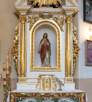 Zdjęcie nr 1: Ołtarz drewniany, prostopadłościenny, na jednostopniowej podstawie. Mensa drewniana z portatylem z marmuru dębnickiego. Antepedium w formie leżącego  prostokąta ujętego grubą ramą, dekorowaną płaskorzeźbionym akantem. W polu, w centrum malowany na desce rollwerk z monogramem IHS, ujęty wolutami utworzonymi z ornamentu roślinnego, o wici zakończonej kampanulą. Tabernakulum w formie prostopadłościennej skrzynki o delikatnie wypukłej ściance frontowej. Całość zamknięta opasującym je z trzech stron gzymsem przyjmującym nad polem środkowym kształt łuku segmentowego podtrzymywanego przez dwie konsole utworzone z akantu. Drzwiczki w kształcie stojącego prostokąta zamkniętego łukiem półkolistym nadwieszonym, w polu ryte przedstawienie kielicha z hostią. Tabernakulum flankowane spływami wolutowymi utworzonymi z akantu.
Nastawa ołtarzowa architektoniczna, jednoosiowa, jednokondygnacyjna ze zwieńczeniem, na niewielkim cokole. Kondygnacja ujęta parą kolumn o kapitelach kompozytowych dźwigających pełne belkowanie wyłamane na ich osi oraz przerwany półkolisty przyczółek. W polu środkowym nisza w formie stojącego prostokąta zamkniętego łukiem półkolistym, ujęta ramą z figurą Najświętszego Serca Jezusa; na zasuwie obraz przedstawiający Ukrzyżowanego Chrystusa. Zwieńczenie w formie medalionu z płaskorzeźbionym monogramem IHS w glorii promienistej. W przyłuczach niszy w polu środkowym para puttów podtrzymujących owalny kartusz z napisem w polu „JEZVS CHRYSTUS / JEDYNY ODKUPICIEL / CZŁOWIEKA / ŚW(IĘTY) PIOTR”. Kondygnacja ujęta uszami utworzonymi z suchego akantu. Gzyms oraz przerwany przyczółek dekorowane kimationem. Struktura polichromowana w kolorze białym, ornamentyka, profile i kolumny złocone.
