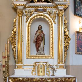 Zdjęcie nr 1: Ołtarz drewniany, prostopadłościenny, na jednostopniowej podstawie. Mensa drewniana z portatylem z marmuru dębnickiego. Antepedium w formie leżącego  prostokąta ujętego grubą ramą, dekorowaną płaskorzeźbionym akantem. W polu, w centrum malowany na desce rollwerk z monogramem IHS, ujęty wolutami utworzonymi z ornamentu roślinnego, o wici zakończonej kampanulą. Tabernakulum w formie prostopadłościennej skrzynki o delikatnie wypukłej ściance frontowej. Całość zamknięta opasującym je z trzech stron gzymsem przyjmującym nad polem środkowym kształt łuku segmentowego podtrzymywanego przez dwie konsole utworzone z akantu. Drzwiczki w kształcie stojącego prostokąta zamkniętego łukiem półkolistym nadwieszonym, w polu ryte przedstawienie kielicha z hostią. Tabernakulum flankowane spływami wolutowymi utworzonymi z akantu.
Nastawa ołtarzowa architektoniczna, jednoosiowa, jednokondygnacyjna ze zwieńczeniem, na niewielkim cokole. Kondygnacja ujęta parą kolumn o kapitelach kompozytowych dźwigających pełne belkowanie wyłamane na ich osi oraz przerwany półkolisty przyczółek. W polu środkowym nisza w formie stojącego prostokąta zamkniętego łukiem półkolistym, ujęta ramą z figurą Najświętszego Serca Jezusa; na zasuwie obraz przedstawiający Ukrzyżowanego Chrystusa. Zwieńczenie w formie medalionu z płaskorzeźbionym monogramem IHS w glorii promienistej. W przyłuczach niszy w polu środkowym para puttów podtrzymujących owalny kartusz z napisem w polu „JEZVS CHRYSTUS / JEDYNY ODKUPICIEL / CZŁOWIEKA / ŚW(IĘTY) PIOTR”. Kondygnacja ujęta uszami utworzonymi z suchego akantu. Gzyms oraz przerwany przyczółek dekorowane kimationem. Struktura polichromowana w kolorze białym, ornamentyka, profile i kolumny złocone.
