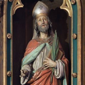 Zdjęcie nr 1: Rzeźba wolnostojąca, pełnoplastyczna ukazująca św. Wojciecha w postawie stojącej w delikatnym kontrapoście. Prawa ręka wysunięta do przodu, w której niegdyś znajdował się niezachowany atrybut świętego, w lewej trzyma księgę oraz palmę męczeństwa. Twarz podłużna, o wzroku skierowanym do góry, długim i wąskim nosie, małych ustach, okolona krótką brodą, policzki delikatnie zarumienione. Włosy siwe, falowane, zasłaniające uszy. Święty jest ubrany w fioletową albę, białą komżę i czerwoną kapę o jasnozielonej podszewce, spiętą na szyi klamrą i zdobioną na brzegach ornamentalnym pasem złożonym z trójlistnych form. Na głowie ma srebrną infułę o złoconych brzegach z równoramiennym krzyżykiem pośrodku i taśmami opadającymi na plecy. Polichromia naturalistyczna w odsłoniętych partiach ciała, atrybuty i elementy stroju złocone, palma męczeństwa w kolorze zielonym. Rzeźba ustawiona na niskim postumencie o ściętych narożach.
