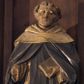 Zdjęcie nr 1: Rzeźba pełnoplastyczna przedstawiająca św. Dominika. Święty ukazany w postawie stojącej, frontalnie, z rękami wyciągniętymi przed siebie, w lewej trzyma księgę. Ma twarz o rysach dojrzałego mężczyzny, z długim i wąskim nosem, wąskimi ustami oraz delikatnie zmarszczonym czołem. Włosy krótkie, na czubku głowy zebrane w oddzielną kępkę. Święty ubrany jest w strój dominikański: biały habit, przewiązany sznurem z czarnym szkaplerzem oraz czarny płaszcz z białym kapturem, na stopach ma czarne buty. Księga w brązowej oprawie. 