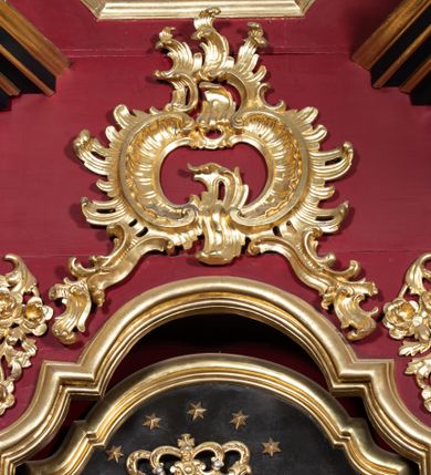 Zdjęcie nr 4: Ołtarz architektoniczny, jednokondygnacyjny, jednoosiowy ze zwieńczeniem. Mensa drewniana, prostopadłościenna. Antepedium ołtarza w kształcie leżącego prostokąta, ujęte profilowaną, polichromowaną, złoconą i srebrzoną ramą z ornamentyką roślinną. Wnętrze wypełnione jasnozieloną tkaniną z monogramem maryjnym pośrodku, zwieńczonym koroną, flankowanym parą gałązek białej lilii. Tabernakulum w kształcie prostopadłościennej skrzynki, ustawione na niskim cokole, ujęte parą wąskich półkolumienek podtrzymujących wyłamane belkowanie. Drzwiczki w kształcie stojącego prostokąta, zamknięte łukiem nadwieszonym z płaskorzeźbionym kielichem z hostią w polu. Nastawa na zdwojonym, uskokowym cokole o ukośnie ustawionych bokach, ujęta parą filarów na rzucie kwadratu i stojącą na ich tle parą kolumn o gładkich trzonach i akantowo-wolutowych kapitelach, wspierających wyłamujące się ponad nimi, skośnie ustawione, przerwane belkowanie z silnie wysuniętym gzymsem. Zwieńczenie w formie kartusza o faliście ukształtowanych bokach, zamknięte przerwanym gzymsem w kształcie łuku wklęsło-wypukłego, flankowane przerwanym przyczółkiem ukształtowanym wolutowo. Pola górnego cokołu retabulum zdobione płycinami o rocaille'owym wykroju. Pole środkowe retabulum w górnej partii zdobione ornamentyką rocaille'ową oraz motywem gałązek różanych. Wewnętrzna strona trzonów filarów w górnej partii zdobiona podwieszeniami w formie gałązek różanych. Akantowo-wolutowe kapitele kolumn i filarów w środkowej części dekorowane motywem rocaille'u. Wewnętrzne krawędzie boków zwieńczenia retabulum zdobione motywem rokokowego grzebienia. Pole środkowe retabulum w formie wnęki w kształcie stojącego prostokąta zamkniętego łukiem wklęsło-wypukłym z uskokami, ujętej profilowaną i złoconą ramą. Wewnątrz obraz Matki Boskiej z Dzieciątkiem. W zwieńczeniu pole w kształcie trapezu o wklęsłych bokach i dolnych narożach, zamkniętego półkolistym łukiem nadwieszonym, ujęte profilowaną i złoconą ramą. W polu znajduje się obraz św. Stanisława Kostki. Struktura polichromowana w kolorze bordowym i czarnym. Detal architektoniczny i ornamentyka złocone i srebrzone. Według dokumentacji konserwatorskiej z 2015 roku na odwrociu kolumny ołtarza znajdują się napisy: „Ołtarz wielki i dwa boczne pozłotnik Bronisław Jentys w 1887 roku, 21 września odnowił” i „ciągle lał deszcz”.
