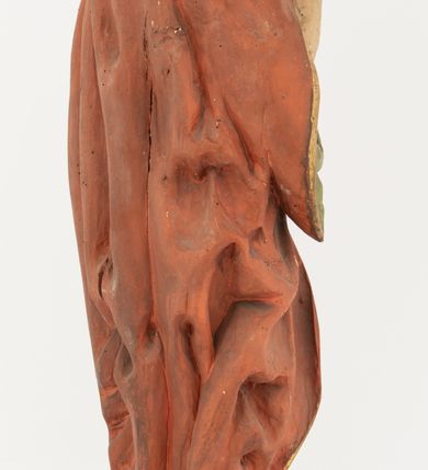 Zdjęcie nr 7: Rzeźba Chrystusa Zmartwychwstałego pełnoplastyczna, wolnostojąca, ustawiona na niskim, półkolistym cokole. Chrystus ukazany w całej postaci, ustawiony frontalnie, prawą ręką czyni gest błogosławieństwa, lewa niezachowana. Twarz podłużna, z długim nosem i małymi oczami, wysokim czołem, okolona krótką i brązową brodą, rozdzieloną na końcu w dwa małe pukle. Włosy długie, brązowe opadające na ramiona i plecy równolegle ułożonymi lokami skręconymi na końcu. Chrystus ubrany jest w czerwony płaszcz z zieloną podszewką, spięty na dekolcie złotą broszką, odsłaniający klatkę piersiową i nogi, otaczający figurę, z prawą połą przerzuconą przez lewe przedramię. Na dłoniach, stopach i boku ma delikatnie zaznaczone ślady męki. Polichromia ciała jest naturalistyczna, lamówka płaszcza złocona. 
