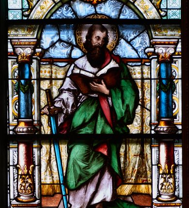 Zdjęcie nr 1: Witraż w kształcie stojącego prostokąta, zamkniętego łukiem odcinkowym. W centrum kompozycji ukazany jest św. Paweł wewnątrz dekoracyjnej aediculi. Święty przedstawiony jest frontalnie, w lewej dłoni trzyma otwartą księgę, a w prawej miecz skierowany ostrzem w dół, głowa skłoniona jest lekko w dół, w stronę księgi. Twarz podłużna w wysokim czołem z zakolami, okolona bujną, długą i ciemnobrązową brodą. Święty ubrany jest w jasnoróżową suknię, zielony płaszcz z czerwoną podszewką, przewieszony przez lewe ramię oraz sandały na stopach; wokół głowy ma kolisty nimb, wypełniony świetlistymi promieniami i złotymi zdobieniami. Aedicula wsparta jest na parach kolumn oraz stojących za nimi filarów, ustawionych na dwustopniowych cokołach. Podpory podtrzymują zwieńczenie z łukiem odcinkowym z przodu. W tle na prostym drążku, zawieszona jest drapowana, złota kotara ze złotymi frędzlami; podłoga ułożona z brązowym płytek. Cokoły kolumn dekorowane są płycinami, wypełnionymi rozetami. Kolumny w połowie przedzielone są opaską, u dołu zdobione stylizowanymi liśćmi akantu, a u góry zielonym festonem. W dolnej części kolumny są koloru czerwonego, w górnej niebieskiego; kapitele kompozytowe. Trzony filarów zdobione prostokątnymi płycinami, wypełnionymi roślinną dekoracją. Łuk zdobiony jest złoconą wicią roślinną i astragalem, w kluczu znajduje się uskrzydlona główka aniołka z czerwonymi skrzydłami. Zwieńczenie dwustopniowe, bogato dekorowane wolutkami i liśćmi akantu, na szczycie przerwany przyczółek, a po środku wazon. W dolnej partii witrażu, pomiędzy cokołami aediculi ozdobny kartusz zdobiony stylizowanym ornamentem okuciowym z prostokątną płyciną w polu z napisem: „S[ANC]T[US] PAULUS” oraz sygnatura artysty Georga Boosa z Monachium.