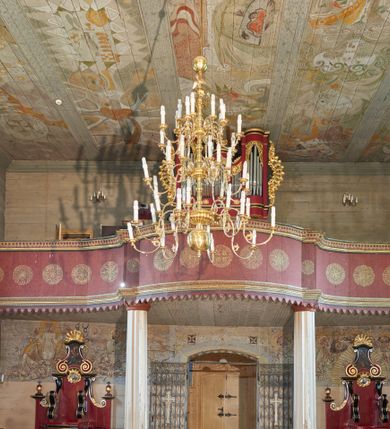 Zdjęcie nr 2: Prospekt organowy architektoniczny, jednokondygnacyjny, pięcioosiowy na cokole. Osie skrajne i oś środkowa są wypukłe, wydzielone ryzalitami z prześwitami wypełnionymi piszczałkami; zwieńczone profilowanym gzymsem. Analogicznie ukształtowany cokolik ujmuje strukturę od dołu. Osie zewnętrzne sięgają stropu, środkowa niższa połączona jest z nimi płaskimi ściankami z prześwitami na piszczałki. Organy ujęte są ażurowymi uszami utworzonymi z wici roślinnej. Na osi środkowej ustawiony jest klasycystyczny wazon. Prześwity w górnej partii każdej osi wypełniają stylizowane liście akantu. Struktura polichromowana w kolorze czerwonym; profilowania złocone i polichromowane na czarno, ornamentyka złocona.