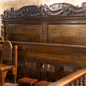 Zdjęcie nr 1: Po obu stronach nawy kościoła są dwa rzędy ławek osadzonych na drewnianych podłogach, po pięć w każdym. Zarówno fronty, zaplecki, jak i policzki są bogato rzeźbione w motywy rozet i lilii zakopiańskich. Boki każdej z ławek wieńczą niewielkie sterczyny w formie tulipanów. 