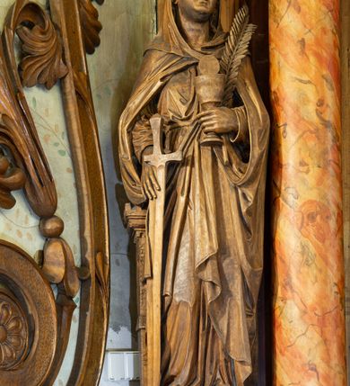 Zdjęcie nr 4: Ołtarz architektoniczny, jednokondygnacyjny, jednoosiowy ze zwieńczeniem. Ołtarz prostopadłościenny z drewnianą mensą, po bokach ujęty uskokowo. Retabulum osadzone na niewysokim, podwójnie zryzalitowanym po bokach cokole, skrajne partie ustawione ukośnie. Część środkowa w formie półkoliście zamkniętej arkady wspartej na parze kolumn i ujętej parą pilastrów. Całość wieńczy wyłamujące się w części środkowej belkowanie. Zwieńczenie ujmuje para kolumn osadzonych na niewielkich cokołach i wspierających gzyms w kształcie trójkątnego przyczółka. Pola uskokowych boków ołtarza zdobią motywy S-kształtnych, ulistnionych wolut, pole antepedium wypełnia fryz arkadkowy. Partie cokołu retabulum zdobią motywy rozet. W kapitelach kolumn jest dekoracja w formie uskrzydlonych główek anielskich. Łuk arkady zdobi ażurowy fryz arkadkowy, natomiast górne pola tej części retabulum motywy czwórliści i S-kształtnych, ulistnionych wolut. Zarówno środkową część retabulum, jak i zwieńczenie ujmują po bokach pary ażurowych uszaków w formie wici  roślinnej. W polu przyczółka jest płaskorzeźbiona promienista gloria z monogramem imienia Jezus pośrodku. Szczyt zwieńczenia w formie krzyża, ujęty po bokach parą wazonów. Pole arkady części środkowej retabulum wypełnia płaskorzeźbiona sylwetka św. Floriana, natomiast po bokach, na tle pilastrów została ustawiona para figur św. Barbary po lewej stronie i św. Szymona po prawej. Pole zwieńczenia w kształcie zbliżonym do kwadratu, ujęte szerokim obramieniem zdobionym ażurowym ornamentem w formie S-kształtnych, ulistnionych wolut. W środku tondo z płaskorzeźbionym wizerunkiem św. Marii Magdaleny. 
Struktura retabulum utrzymana w kolorze drewna, trzony kolumn i część detali architektonicznych marmoryzowane.         
