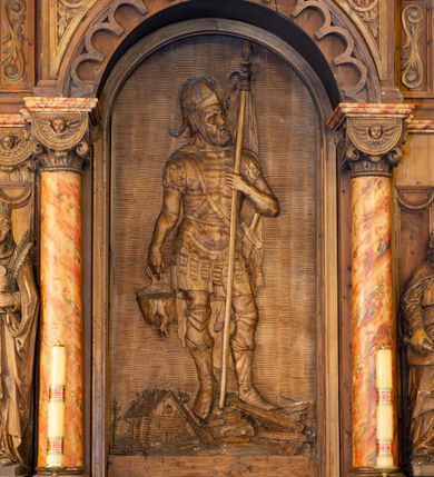 Zdjęcie nr 2: Ołtarz architektoniczny, jednokondygnacyjny, jednoosiowy ze zwieńczeniem. Ołtarz prostopadłościenny z drewnianą mensą, po bokach ujęty uskokowo. Retabulum osadzone na niewysokim, podwójnie zryzalitowanym po bokach cokole, skrajne partie ustawione ukośnie. Część środkowa w formie półkoliście zamkniętej arkady wspartej na parze kolumn i ujętej parą pilastrów. Całość wieńczy wyłamujące się w części środkowej belkowanie. Zwieńczenie ujmuje para kolumn osadzonych na niewielkich cokołach i wspierających gzyms w kształcie trójkątnego przyczółka. Pola uskokowych boków ołtarza zdobią motywy S-kształtnych, ulistnionych wolut, pole antepedium wypełnia fryz arkadkowy. Partie cokołu retabulum zdobią motywy rozet. W kapitelach kolumn jest dekoracja w formie uskrzydlonych główek anielskich. Łuk arkady zdobi ażurowy fryz arkadkowy, natomiast górne pola tej części retabulum motywy czwórliści i S-kształtnych, ulistnionych wolut. Zarówno środkową część retabulum, jak i zwieńczenie ujmują po bokach pary ażurowych uszaków w formie wici  roślinnej. W polu przyczółka jest płaskorzeźbiona promienista gloria z monogramem imienia Jezus pośrodku. Szczyt zwieńczenia w formie krzyża, ujęty po bokach parą wazonów. Pole arkady części środkowej retabulum wypełnia płaskorzeźbiona sylwetka św. Floriana, natomiast po bokach, na tle pilastrów została ustawiona para figur św. Barbary po lewej stronie i św. Szymona po prawej. Pole zwieńczenia w kształcie zbliżonym do kwadratu, ujęte szerokim obramieniem zdobionym ażurowym ornamentem w formie S-kształtnych, ulistnionych wolut. W środku tondo z płaskorzeźbionym wizerunkiem św. Marii Magdaleny. 
Struktura retabulum utrzymana w kolorze drewna, trzony kolumn i część detali architektonicznych marmoryzowane.         
