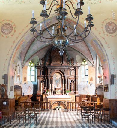 Zdjęcie nr 3: Ołtarz architektoniczny, jednokondygnacyjny, trójosiowy, ze zwieńczeniem. Ołtarz prostopadłościenny, kamienny, ustawiony na podstawie, w drewnianej obudowie. Mensa drewniana z marmurowym portatylem. Tabernakulum w formie prostopadłościennej metalowej skrzynki w drewnianej obudowie. Metalowe drzwiczki zdobi motyw kielicha eucharystycznego. Tabernakulum ujęte jest po bokach parą wolnostojących kolumienek wspierających wysunięte ponad nimi, wieńczące je belkowanie z wysokim fryzem. W partii belkowania nad drzwiczkami arkada dekorowana koronką i maswerkowymi rozetami w przyłuczach. Na belkowaniu tron wystawienia, na którym ustawiony krucyfiks. Osadzona na cokole nastawa ołtarza ma formę trójprzelotowego łuku triumfalnego. Część środkowa w kształcie półkolistej arkady wspartej na dwóch parach kolumn, z których wewnętrzne są cofnięte względem zewnętrznych. Arkady artykułujące osie boczne są mniejsze, ujmuje je po jednej parze kolumn wspierających zryzalitowane cokoły flankujące pola wypełnione fryzem arkadkowym. Zwieńczenie ołtarza ujmuje para kolumn wspierających gzyms w formie trójkątnego przyczółka. Pola cokołów retabulum zdobi stylizowana ornamentyka roślinna, kapitele kolumn oraz zwieńczenia arkad osi bocznych motywy uskrzydlonych główek anielskich. Krawędź łuku arkady części środkowej obiega fryz arkadkowy. W przyłuczach arkady ażurowe maswerki. Gzyms wieńczący kondygnację retabulum ujmuje motyw konsolek w formie liści akantu. Zwieńczenie flankowane parą ażurowych uszaków w postaci ornamentu roślinnego, parą figur aniołów oraz dwiema parami wazonów. Pole przyczółka wypełnia płaskorzeźbione przedstawienie gołębicy Ducha Świętego na tle promienistej glorii. Po jego bokach znajduje się para wazonów, szczyt jest w formie krzyża. Zwieńczenie flankują dwie figury aniołów ujęte po bokach dwoma parami wazonów.  
Pole części środkowej w kształcie stojącego prostokąta zamkniętego półkoliście z obrazem Madonny z Dzieciątkiem. W niszach osi bocznych są figury św. Piotra po prawej stronie i św. Pawła po lewej. Kształt pola zwieńczenia jest zbliżony do kwadratu ujętego szerokim obramieniem zdobionym parami S-kształtnych wolut. W środku znajduje się tondo z płaskorzeźbionym przedstawieniem anioła trzymającego kwiat lilii. 

Struktura retabulum utrzymana w kolorze drewna, trzony kolumn i część detali architektonicznych marmoryzowane, tła osi bocznych polichromowane w kolorze ciemnoniebieskim.    

