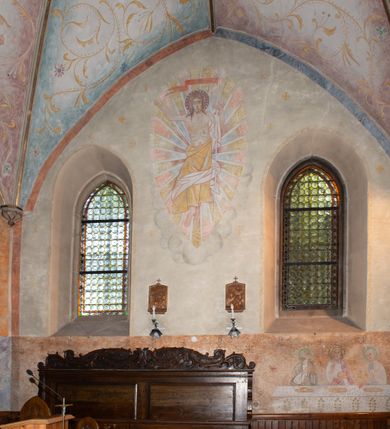 Zdjęcie nr 2: Polichromia obejmuje powierzchnie sklepień i ścian prezbiterium oraz korpusu nawowego. W partii sklepień przybiera formę ulistnionych wici roślinnych w kolorze żółtym z kolorowymi kwiatkami, na tłach w kolorach niebieskim, fioletowym czy zielonym. Polichromia ścian prezbiterium jest dwustrefowa – w dolnej partii, do wysokości okien, na monochromatycznych tłach w kolorze m.in. brązu czy granatu znajdują się sceny figuralne – na południowo-wschodniej ścianie jest Pieta, na południowej – Wieczerza w Emaus z siedzącym przy stole Jezusem pomiędzy dwoma uczniami. Pozostałą powierzchnię ścian zajmują sceny ukazane na białym tle. Na ścianie północnej Ukrzyżowanie, gdzie Jezus jest przedstawiony na krzyżu w formie Drzewa Życia, po lewej stronie stoi Matka Boska, po prawej św. Jan Ewangelista. Na południowej ścianie został ukazany Chrystus Zmartwychwstały na tle promienistej glorii. Postaci charakteryzują smukłe, schematycznie opracowane sylwetki, drapowania szat – syntetyzm, natomiast kolorystyka utrzymana jest w odcieniach pastelowych.   