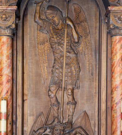 Zdjęcie nr 2: Ołtarz architektoniczny, jednokondygnacyjny, jednoosiowy ze zwieńczeniem. Ołtarz prostopadłościenny z drewnianą mensą, po bokach ujęty uskokowo. Retabulum osadzone na niewysokim, podwójnie zryzalitowanym po bokach cokole, skrajne partie ustawione ukośnie. Część środkowa w formie półkoliście zamkniętej arkady wspartej na parze kolumn i ujętej parą pilastrów. Całość wieńczy wyłamujące się w części środkowej belkowanie. Zwieńczenie ujmuje para kolumn osadzonych na niewielkich cokołach i wspierających gzyms w kształcie trójkątnego przyczółka. Pola uskokowych boków ołtarza zdobią motywy S-kształtnych, ulistnionych wolut, pole antepedium wypełnia fryz arkadkowy. Partie cokołu retabulum zdobią motywy rozet. W kapitelach kolumn jest dekoracja w formie uskrzydlonych główek anielskich. Łuk arkady zdobi ażurowy fryz arkadkowy, natomiast górne pola tej części retabulum motywy czwórliści i S-kształtnych, ulistnionych wolut. Zarówno środkową część retabulum, jak i zwieńczenie ujmują po bokach pary ażurowych uszaków w formie wici roślinnej. W polu przyczółka jest płaskorzeźbiona promienista gloria z monogramem maryjnym pośrodku. Szczyt zwieńczenia w formie krzyża. Pole arkady części środkowej retabulum wypełnia płaskorzeźbiona sylwetka św. Michała Archanioła, natomiast po bokach, na tle pilastrów została ustawiona para figur św. Katarzyny Aleksandryjskiej po prawej stronie i św. Andrzeja po lewej. Pole zwieńczenia w kształcie zbliżonym do kwadratu, ujęte szerokim obramieniem zdobionym ażurowym ornamentem w formie S-kształtnych, ulistnionych wolut. W środku jest tondo z płaskorzeźbionym wizerunkiem św. Jana Chrzciciela. 
Struktura retabulum utrzymana w kolorze drewna, trzony kolumn i część detali architektonicznych marmoryzowane.         
