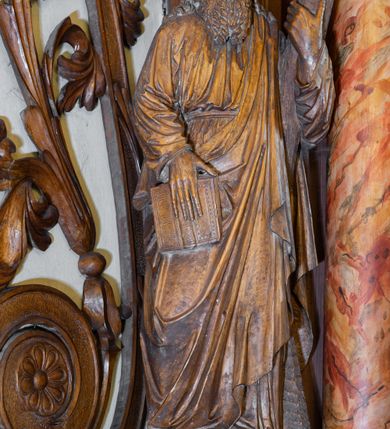 Zdjęcie nr 4: Ołtarz architektoniczny, jednokondygnacyjny, jednoosiowy ze zwieńczeniem. Ołtarz prostopadłościenny z drewnianą mensą, po bokach ujęty uskokowo. Retabulum osadzone na niewysokim, podwójnie zryzalitowanym po bokach cokole, skrajne partie ustawione ukośnie. Część środkowa w formie półkoliście zamkniętej arkady wspartej na parze kolumn i ujętej parą pilastrów. Całość wieńczy wyłamujące się w części środkowej belkowanie. Zwieńczenie ujmuje para kolumn osadzonych na niewielkich cokołach i wspierających gzyms w kształcie trójkątnego przyczółka. Pola uskokowych boków ołtarza zdobią motywy S-kształtnych, ulistnionych wolut, pole antepedium wypełnia fryz arkadkowy. Partie cokołu retabulum zdobią motywy rozet. W kapitelach kolumn jest dekoracja w formie uskrzydlonych główek anielskich. Łuk arkady zdobi ażurowy fryz arkadkowy, natomiast górne pola tej części retabulum motywy czwórliści i S-kształtnych, ulistnionych wolut. Zarówno środkową część retabulum, jak i zwieńczenie ujmują po bokach pary ażurowych uszaków w formie wici roślinnej. W polu przyczółka jest płaskorzeźbiona promienista gloria z monogramem maryjnym pośrodku. Szczyt zwieńczenia w formie krzyża. Pole arkady części środkowej retabulum wypełnia płaskorzeźbiona sylwetka św. Michała Archanioła, natomiast po bokach, na tle pilastrów została ustawiona para figur św. Katarzyny Aleksandryjskiej po prawej stronie i św. Andrzeja po lewej. Pole zwieńczenia w kształcie zbliżonym do kwadratu, ujęte szerokim obramieniem zdobionym ażurowym ornamentem w formie S-kształtnych, ulistnionych wolut. W środku jest tondo z płaskorzeźbionym wizerunkiem św. Jana Chrzciciela. 
Struktura retabulum utrzymana w kolorze drewna, trzony kolumn i część detali architektonicznych marmoryzowane.         
