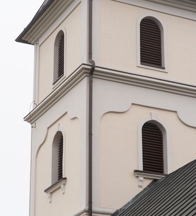 Zdjęcie nr 10: Kościół orientowany, murowany, jednonawowy, z trójbocznie zamkniętym prezbiterium z zakrystią od północy i kruchtą przylegającą do nawy od południa. Prezbiterium jest niższe i węższe od nawy, obie części mają gładkie ściany przeprute jedynie oknami w kształcie stojącego prostokąta zamkniętego łukiem półkolistym – cztery w prezbiterium, sześć w nawie. Sklepienia obu części zwierciadlane. Od południa chór o prostej balustradzie, wsparty na dwóch kolumnach. Ściany pokrywa polichromia ze scenami i cytatami z Pisma Świętego, postaciami świętych oraz żyjących, a także o motywach dekoracyjnych – roślinnych. Do około jednej czwartej wysokości ścian okładzina.  Zachodnią elewację frontową kościoła tworzy trójosiowa, wieżowa fasada. Oś kompozycji stanowi wysunięta ryzalitowo czterokondygnacyjna wieża. Ściana czołowa wieży dekorowana w pierwszej i drugiej kondygnacji boniowaniem i oknami w kształcie leżącego prostokąta osłoniętymi ozdobną kratą, z portalem o wykroju prostokątnym, ponad którym napis „DEO SOLI GLORIA”. W drugiej i trzeciej kondygnacji okna o wykroju stojącego prostokąta zamkniętego łukiem pełnym. Niżej w płycinie zwieńczonej łukiem nadwieszonym, wyżej w prostokątnej. Kondygnacje rozdzielone za pomocą masywnych gzymsów. Całość zwieńczona dachem namiotowym z kulą i krzyżem. Osie boczne cofnięte w stosunku do wysuniętej wieży i zrytmizowane podziałem ramowym, wypełnione wklęsłą płyciną w formie wydłużonego, stojącego prostokąta. Nad gzymsem fragment przyczółka przysłonięty wieżą. Elewacje boczne i tylna ukształtowane jednorodnie, gładkie, przeprute jedynie oknami. Wszystkie dachy blaszane – nad nawą i kruchtą dwuspadowy, nad zakrystią pulpitowy, nad prezbiterium zamknięty wielobocznie. 
Wartymi uwagi elementami wyposażenia kościoła jest siedemnastowieczny ołtarz boczny prawy z późniejszymi o wiek wizerunkami św. Katarzyny i św. Wawrzyńca, bogato rzeźbiona ława kolatorska i siedemnastowieczna chrzcielnica. 