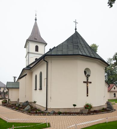 Zdjęcie nr 9: Kościół orientowany, murowany, jednonawowy, z trójbocznie zamkniętym prezbiterium z zakrystią od północy i kruchtą przylegającą do nawy od południa. Prezbiterium jest niższe i węższe od nawy, obie części mają gładkie ściany przeprute jedynie oknami w kształcie stojącego prostokąta zamkniętego łukiem półkolistym – cztery w prezbiterium, sześć w nawie. Sklepienia obu części zwierciadlane. Od południa chór o prostej balustradzie, wsparty na dwóch kolumnach. Ściany pokrywa polichromia ze scenami i cytatami z Pisma Świętego, postaciami świętych oraz żyjących, a także o motywach dekoracyjnych – roślinnych. Do około jednej czwartej wysokości ścian okładzina.  Zachodnią elewację frontową kościoła tworzy trójosiowa, wieżowa fasada. Oś kompozycji stanowi wysunięta ryzalitowo czterokondygnacyjna wieża. Ściana czołowa wieży dekorowana w pierwszej i drugiej kondygnacji boniowaniem i oknami w kształcie leżącego prostokąta osłoniętymi ozdobną kratą, z portalem o wykroju prostokątnym, ponad którym napis „DEO SOLI GLORIA”. W drugiej i trzeciej kondygnacji okna o wykroju stojącego prostokąta zamkniętego łukiem pełnym. Niżej w płycinie zwieńczonej łukiem nadwieszonym, wyżej w prostokątnej. Kondygnacje rozdzielone za pomocą masywnych gzymsów. Całość zwieńczona dachem namiotowym z kulą i krzyżem. Osie boczne cofnięte w stosunku do wysuniętej wieży i zrytmizowane podziałem ramowym, wypełnione wklęsłą płyciną w formie wydłużonego, stojącego prostokąta. Nad gzymsem fragment przyczółka przysłonięty wieżą. Elewacje boczne i tylna ukształtowane jednorodnie, gładkie, przeprute jedynie oknami. Wszystkie dachy blaszane – nad nawą i kruchtą dwuspadowy, nad zakrystią pulpitowy, nad prezbiterium zamknięty wielobocznie. 
Wartymi uwagi elementami wyposażenia kościoła jest siedemnastowieczny ołtarz boczny prawy z późniejszymi o wiek wizerunkami św. Katarzyny i św. Wawrzyńca, bogato rzeźbiona ława kolatorska i siedemnastowieczna chrzcielnica. 