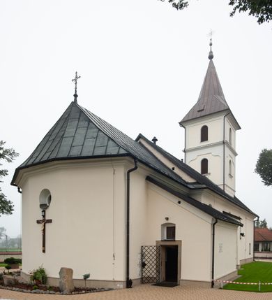 Zdjęcie nr 11: Kościół orientowany, murowany, jednonawowy, z trójbocznie zamkniętym prezbiterium z zakrystią od północy i kruchtą przylegającą do nawy od południa. Prezbiterium jest niższe i węższe od nawy, obie części mają gładkie ściany przeprute jedynie oknami w kształcie stojącego prostokąta zamkniętego łukiem półkolistym – cztery w prezbiterium, sześć w nawie. Sklepienia obu części zwierciadlane. Od południa chór o prostej balustradzie, wsparty na dwóch kolumnach. Ściany pokrywa polichromia ze scenami i cytatami z Pisma Świętego, postaciami świętych oraz żyjących, a także o motywach dekoracyjnych – roślinnych. Do około jednej czwartej wysokości ścian okładzina.  Zachodnią elewację frontową kościoła tworzy trójosiowa, wieżowa fasada. Oś kompozycji stanowi wysunięta ryzalitowo czterokondygnacyjna wieża. Ściana czołowa wieży dekorowana w pierwszej i drugiej kondygnacji boniowaniem i oknami w kształcie leżącego prostokąta osłoniętymi ozdobną kratą, z portalem o wykroju prostokątnym, ponad którym napis „DEO SOLI GLORIA”. W drugiej i trzeciej kondygnacji okna o wykroju stojącego prostokąta zamkniętego łukiem pełnym. Niżej w płycinie zwieńczonej łukiem nadwieszonym, wyżej w prostokątnej. Kondygnacje rozdzielone za pomocą masywnych gzymsów. Całość zwieńczona dachem namiotowym z kulą i krzyżem. Osie boczne cofnięte w stosunku do wysuniętej wieży i zrytmizowane podziałem ramowym, wypełnione wklęsłą płyciną w formie wydłużonego, stojącego prostokąta. Nad gzymsem fragment przyczółka przysłonięty wieżą. Elewacje boczne i tylna ukształtowane jednorodnie, gładkie, przeprute jedynie oknami. Wszystkie dachy blaszane – nad nawą i kruchtą dwuspadowy, nad zakrystią pulpitowy, nad prezbiterium zamknięty wielobocznie. 
Wartymi uwagi elementami wyposażenia kościoła jest siedemnastowieczny ołtarz boczny prawy z późniejszymi o wiek wizerunkami św. Katarzyny i św. Wawrzyńca, bogato rzeźbiona ława kolatorska i siedemnastowieczna chrzcielnica. 