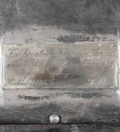 Zdjęcie nr 11: Plakietka z przedstawieniem Matki Boskiej Kodeńskiej w otoczeniu Lwa Sapiehy, Mikołaja III Sapiehy, św. Kazimierza, bł. Jozafata Kuncewicza i nierozpoznanej świętej mniszki, a także z herbem złożonym Sapiechów i Pogonią. Na cokole pod wizerunkiem Mikołaja Sapiechy napis: „NICOALVS (?) PIVS DICTVS / CASTELLANVS VILNENSIS / ECCLESIAE KODENENSIS FVUNDATOR +1644”, z kolei pod wzierunkiem Lwa Sapiechy: „LEO COMES SAPIEHA PALATINVS VILNENSIS / CANCELLARIVS ET DVX EXERCITTVM / M.D.L. 1633”. Na odwrociu tabliczka z napisem: „Kardynałowi Adamowi Sapieże / wizerunek Najśw(iętszej) Panny Kodeńskiej / ofiaruje: / Rodzina / Kraków 1946.”