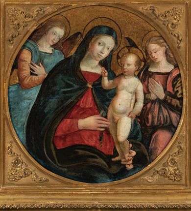 Zdjęcie nr 1: Obraz w formie medalionu w kwadratowej ramie z przedstawieniem Matki Boskiej z Dzieciątkiem oraz dwóch adorujących aniołów. W centrum kompozycji Matka Boska z pochyloną w lewą stronę głową, ukazana jako siedząca, która lewą dłonią przytrzymuje stojące Dzieciątko, a w prawej trzyma chusteczkę. Twarz ma trójkątną o małych oczach i ustach, z długim nosem. Ubrana jest w czerwoną suknię oraz niebieski płaszcz z zieloną podszewką, spięty pod szyją złotą klamrą, zarzucony na głowę i otulający całą postać. Dzieciątko ukazane nagie, zwrócone delikatnie w prawo, lewą rączkę opiera na biodrze, a prawą błogosławi. Twarz ma pełną o rysach dziecięcych, silnie zarumienioną na policzkach, okoloną jasnymi włosami, wokół głowy ma nimb krzyżowy. Po bokach stoją aniołowie, delikatnie pochyleni ku środkowi. Anioł po lewej stronie ma skrzyżowane na piersi ręce. Ubrany jest w żółtą suknię z długimi rękawami oraz niebieską tunikę. Anioł po prawej stronie składa ręce w geście modlitwy. Jets ubrany w brązową suknię z długimi rękawami oraz czerwoną tunikę. Obaj mają delikatne rysy twarzy oraz długie i jasne włosy. Maria oraz aniołowie mają wokół głów koliste nimby nakreślone czarnym konturem. Tło jednolite, złocone. Rama kwadratowa z polem obrazowym w kształcie medalionu, zdobiona na brzegu motywem skręconego sznura, a w przyłuczach stylizowanymi liśćmi akantu. Na odwrociu kartka z drukowanym napisem „Ze zbiorów księdza Jana kniazia z Kozielska Puzyny księcia biskupa krakowskiego, no 11”.
