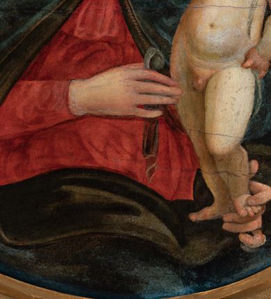 Zdjęcie nr 5: Obraz w formie medalionu w kwadratowej ramie z przedstawieniem Matki Boskiej z Dzieciątkiem oraz dwóch adorujących aniołów. W centrum kompozycji Matka Boska z pochyloną w lewą stronę głową, ukazana jako siedząca, która lewą dłonią przytrzymuje stojące Dzieciątko, a w prawej trzyma chusteczkę. Twarz ma trójkątną o małych oczach i ustach, z długim nosem. Ubrana jest w czerwoną suknię oraz niebieski płaszcz z zieloną podszewką, spięty pod szyją złotą klamrą, zarzucony na głowę i otulający całą postać. Dzieciątko ukazane nagie, zwrócone delikatnie w prawo, lewą rączkę opiera na biodrze, a prawą błogosławi. Twarz ma pełną o rysach dziecięcych, silnie zarumienioną na policzkach, okoloną jasnymi włosami, wokół głowy ma nimb krzyżowy. Po bokach stoją aniołowie, delikatnie pochyleni ku środkowi. Anioł po lewej stronie ma skrzyżowane na piersi ręce. Ubrany jest w żółtą suknię z długimi rękawami oraz niebieską tunikę. Anioł po prawej stronie składa ręce w geście modlitwy. Jets ubrany w brązową suknię z długimi rękawami oraz czerwoną tunikę. Obaj mają delikatne rysy twarzy oraz długie i jasne włosy. Maria oraz aniołowie mają wokół głów koliste nimby nakreślone czarnym konturem. Tło jednolite, złocone. Rama kwadratowa z polem obrazowym w kształcie medalionu, zdobiona na brzegu motywem skręconego sznura, a w przyłuczach stylizowanymi liśćmi akantu. Na odwrociu kartka z drukowanym napisem „Ze zbiorów księdza Jana kniazia z Kozielska Puzyny księcia biskupa krakowskiego, no 11”.
