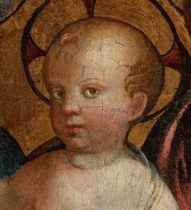 Zdjęcie nr 6: Obraz w formie medalionu w kwadratowej ramie z przedstawieniem Matki Boskiej z Dzieciątkiem oraz dwóch adorujących aniołów. W centrum kompozycji Matka Boska z pochyloną w lewą stronę głową, ukazana jako siedząca, która lewą dłonią przytrzymuje stojące Dzieciątko, a w prawej trzyma chusteczkę. Twarz ma trójkątną o małych oczach i ustach, z długim nosem. Ubrana jest w czerwoną suknię oraz niebieski płaszcz z zieloną podszewką, spięty pod szyją złotą klamrą, zarzucony na głowę i otulający całą postać. Dzieciątko ukazane nagie, zwrócone delikatnie w prawo, lewą rączkę opiera na biodrze, a prawą błogosławi. Twarz ma pełną o rysach dziecięcych, silnie zarumienioną na policzkach, okoloną jasnymi włosami, wokół głowy ma nimb krzyżowy. Po bokach stoją aniołowie, delikatnie pochyleni ku środkowi. Anioł po lewej stronie ma skrzyżowane na piersi ręce. Ubrany jest w żółtą suknię z długimi rękawami oraz niebieską tunikę. Anioł po prawej stronie składa ręce w geście modlitwy. Jets ubrany w brązową suknię z długimi rękawami oraz czerwoną tunikę. Obaj mają delikatne rysy twarzy oraz długie i jasne włosy. Maria oraz aniołowie mają wokół głów koliste nimby nakreślone czarnym konturem. Tło jednolite, złocone. Rama kwadratowa z polem obrazowym w kształcie medalionu, zdobiona na brzegu motywem skręconego sznura, a w przyłuczach stylizowanymi liśćmi akantu. Na odwrociu kartka z drukowanym napisem „Ze zbiorów księdza Jana kniazia z Kozielska Puzyny księcia biskupa krakowskiego, no 11”.
