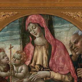 Zdjęcie nr 1: Obraz w formie medalionu w kwadratowej ramie z przedstawieniem Matki Boskiej z Dzieciątkiem, ze św. Janem Chrzcicielem i św. Józefem. W centrum kompozycji Matka Boska ukazana jako siedząca z głową delikatnie pochyloną w prawo, dłońmi przytrzymuje siedzące Dzieciątko. Twarz ma trójkątną o małych, półprzymkniętych oczach; długim i prostym nosie oraz wąskich ustach. Ubrana jest w jasnobrązową suknię oraz czerwony płaszcz z zieloną podszewką, zarzucony na głowę i otulający całą postać, na głowie ma  także biały welon. Dzieciątko w pozycji półleżącej, ukazane nagie, zwrócone ku św. Janowi Chrzcicielowi i obejmujące go prawą rączką za szyję. Twarz ma pełną o małych oczach, małym nosie i ustach, silnie zarumienioną na policzkach, okoloną jasnymi i kręconymi włosami. Z lewej strony obrazu na wysokim, kamiennym cokole przyklęka na prawe kolano  św. Jan Chrzciciel, ukazany jako kilkuletnie dziecko, zwrócony trzy czwarte w lewo, z delikatnie uniesioną głową. W rękach trzyma laskę zakończoną krzyżem. Twarz ma dziecięcą o pełnych policzkach, małych oczach skierowanych w górę, małym nosie i ustach, okoloną jasnymi i krótkimi włosami. Jego ciało przesłonięte jest w partii torsu i nóg brązową melotą. Po prawej stronie obrazu stoi św. Józef, zwrócony trzy czwarte w prawo, lewą ręką wspiera się na kiju pasterskim, a prawą trzyma się za głowę. Ubrany jest w niebieską suknię i żółty płaszcz. Twarz szeroka z wydatnym podbródkiem i długim nosem, włosy siwe i krótkie. Wokół głów św. Józef, Matka Boska i św. Jan Chrzciciel mają złote, okrągłe nimby. Karnacje postaci w odcieniu szarym, bladym; kolorystyka pastelowa. W oddali pejzaż górki, niebo różowo-niebieskie. Za Matką Boską pionowy, zielony pas kotary (?). Rama kwadratowa z polem obrazowym w kształcie medalionu, zdobiona na brzegu pasami kimationu, profilowaniem, a w przyłuczach stylizowanymi liśćmi akantu. 
