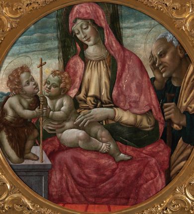 Zdjęcie nr 2: Obraz w formie medalionu w kwadratowej ramie z przedstawieniem Matki Boskiej z Dzieciątkiem, ze św. Janem Chrzcicielem i św. Józefem. W centrum kompozycji Matka Boska ukazana jako siedząca z głową delikatnie pochyloną w prawo, dłońmi przytrzymuje siedzące Dzieciątko. Twarz ma trójkątną o małych, półprzymkniętych oczach; długim i prostym nosie oraz wąskich ustach. Ubrana jest w jasnobrązową suknię oraz czerwony płaszcz z zieloną podszewką, zarzucony na głowę i otulający całą postać, na głowie ma  także biały welon. Dzieciątko w pozycji półleżącej, ukazane nagie, zwrócone ku św. Janowi Chrzcicielowi i obejmujące go prawą rączką za szyję. Twarz ma pełną o małych oczach, małym nosie i ustach, silnie zarumienioną na policzkach, okoloną jasnymi i kręconymi włosami. Z lewej strony obrazu na wysokim, kamiennym cokole przyklęka na prawe kolano  św. Jan Chrzciciel, ukazany jako kilkuletnie dziecko, zwrócony trzy czwarte w lewo, z delikatnie uniesioną głową. W rękach trzyma laskę zakończoną krzyżem. Twarz ma dziecięcą o pełnych policzkach, małych oczach skierowanych w górę, małym nosie i ustach, okoloną jasnymi i krótkimi włosami. Jego ciało przesłonięte jest w partii torsu i nóg brązową melotą. Po prawej stronie obrazu stoi św. Józef, zwrócony trzy czwarte w prawo, lewą ręką wspiera się na kiju pasterskim, a prawą trzyma się za głowę. Ubrany jest w niebieską suknię i żółty płaszcz. Twarz szeroka z wydatnym podbródkiem i długim nosem, włosy siwe i krótkie. Wokół głów św. Józef, Matka Boska i św. Jan Chrzciciel mają złote, okrągłe nimby. Karnacje postaci w odcieniu szarym, bladym; kolorystyka pastelowa. W oddali pejzaż górki, niebo różowo-niebieskie. Za Matką Boską pionowy, zielony pas kotary (?). Rama kwadratowa z polem obrazowym w kształcie medalionu, zdobiona na brzegu pasami kimationu, profilowaniem, a w przyłuczach stylizowanymi liśćmi akantu. 
