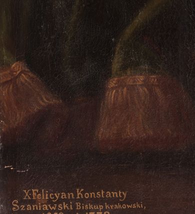 Zdjęcie nr 6: Obraz w kształcie stojącego prostokąta z przedstawieniem biskupa Konstantego Felicjana Szaniawskiego w centrum kompozycji. Biskup ukazany jest w postawie stojącej, delikatnie zwrócony w prawo, w lewej dłoni trzyma chusteczkę, a prawą ujmuje krzyż pektoralny, który ma zawieszony na szyi. Twarz pełna z wyraźnie zaznaczonym podbródkiem, małe oczy, prosty nos i wąskie usta. Włosy ciemne, bujne, średniej długości. Biskup ubrany jest w niebieską sutannę, rokietę, niebieski mucet z czerwoną podszewką i niebieską piuskę.  Po lewej stronie obrazu stolik, nakryty zielonym obrusem, a na nim ustawiony jest krucyfiks i dzwoneczek. U góry obrazu podwieszona czerwona kotara z zawieszonym na sznurach kartuszem z tarczą herbową, u spodu którego zawieszony jest złoty chwost. Nad tarczą herbową umieszczony jest czerwony kapelusz z chwostami, a na jej tle znajdują się skrzyżowane pastorał oraz miecz, a pomiędzy nimi mitra książęca i infuła. W polu tarczy herbowej godło Junosza. W lewym, dolnym narożu obrazu napis „X(iążę) Felicyan Konstanty / Szaniawski Biskup krakowski, / *1668; + 1732.” Rama drewniana, złocona, profilowana. Na odwrociu napis białą farbą: „ODNOWIONO / W MAJU 1979 r. / JAKO DAR ZA PRZYJAZD / DO POLSKI / OJCA ŚWIĘTEGO JANA PAWŁA II / KONS(ERWATOR) Maria Niedzielska”.
